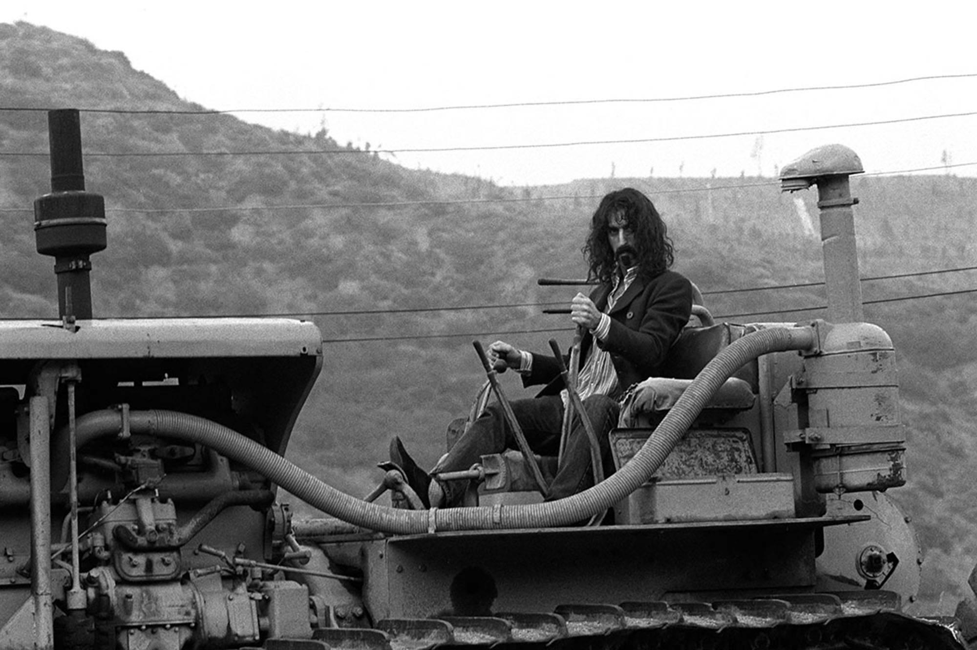 Baron Wolman Black and White Photograph - Frank Zappa on tractor B&W