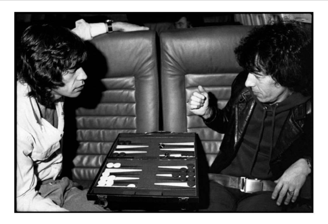 Michael Halsband Portrait Photograph - Mick Jagger & Bill Wyman playing Backgammon on the Tour Jet