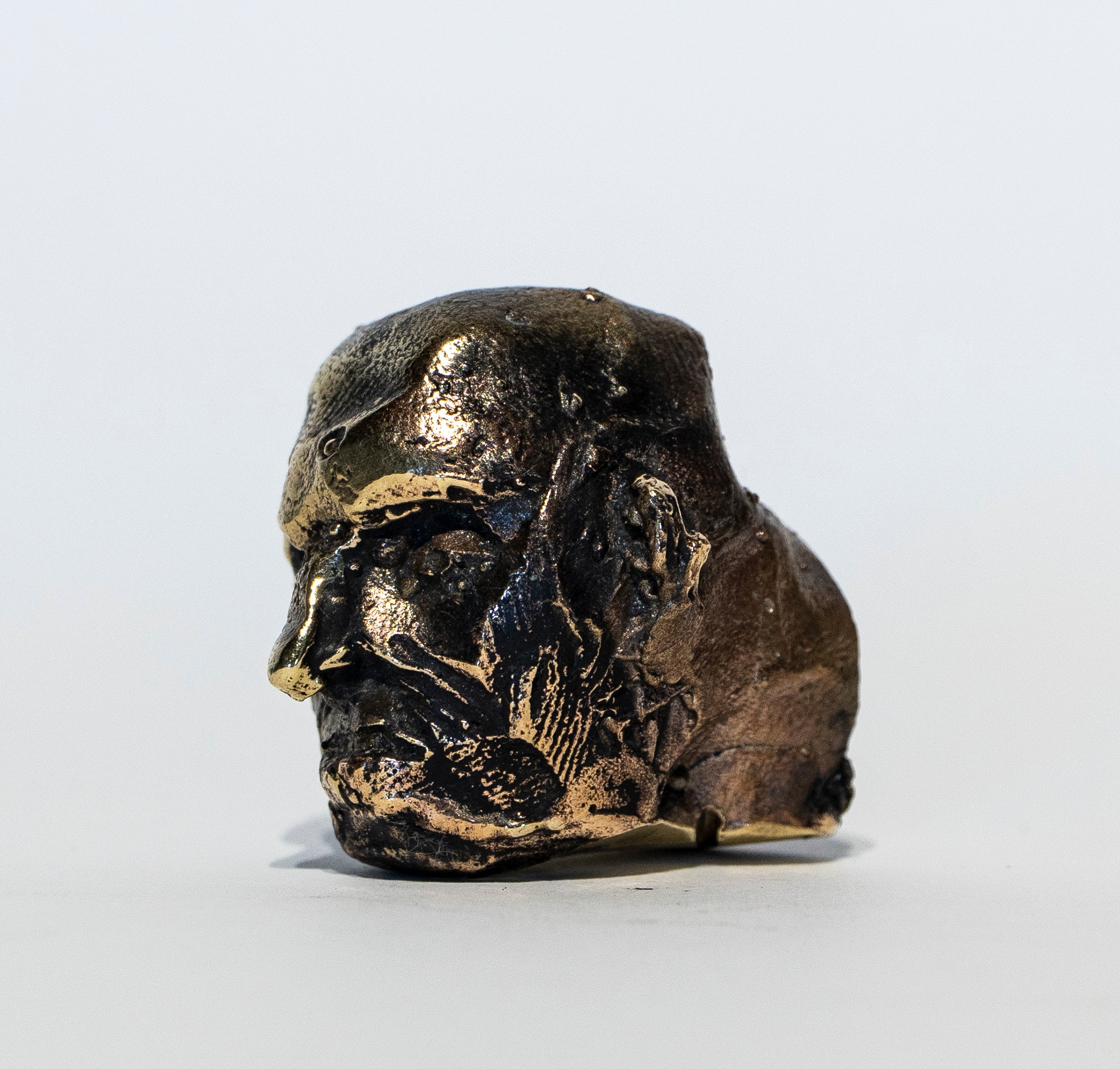 Archaic Dark Patinated Bronze Pocket Head Sculpture with Golden Highlights