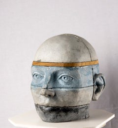 Sculpture architecturale en béton représentant une tête, avec des couches de bois de châtaignier et de gris bleu
