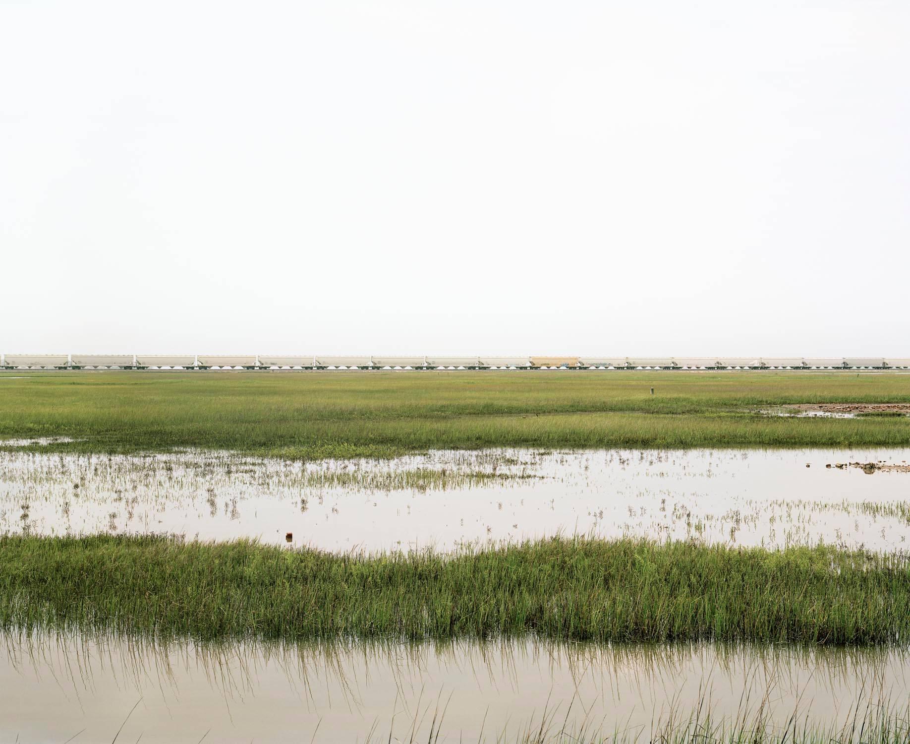 Victoria Sambunaris Landscape Photograph - Untitled (Train Crossing Estuarial Corridor - 2), Virginia Point, Texas