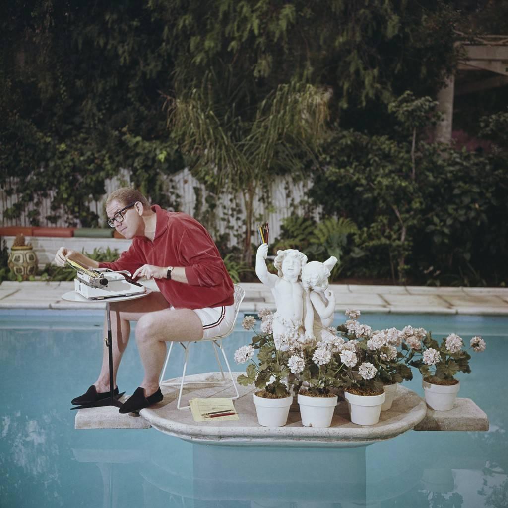 Slim Aarons Color Photograph - Working On Water, 1962: Stan Freberg working in his swimming pool