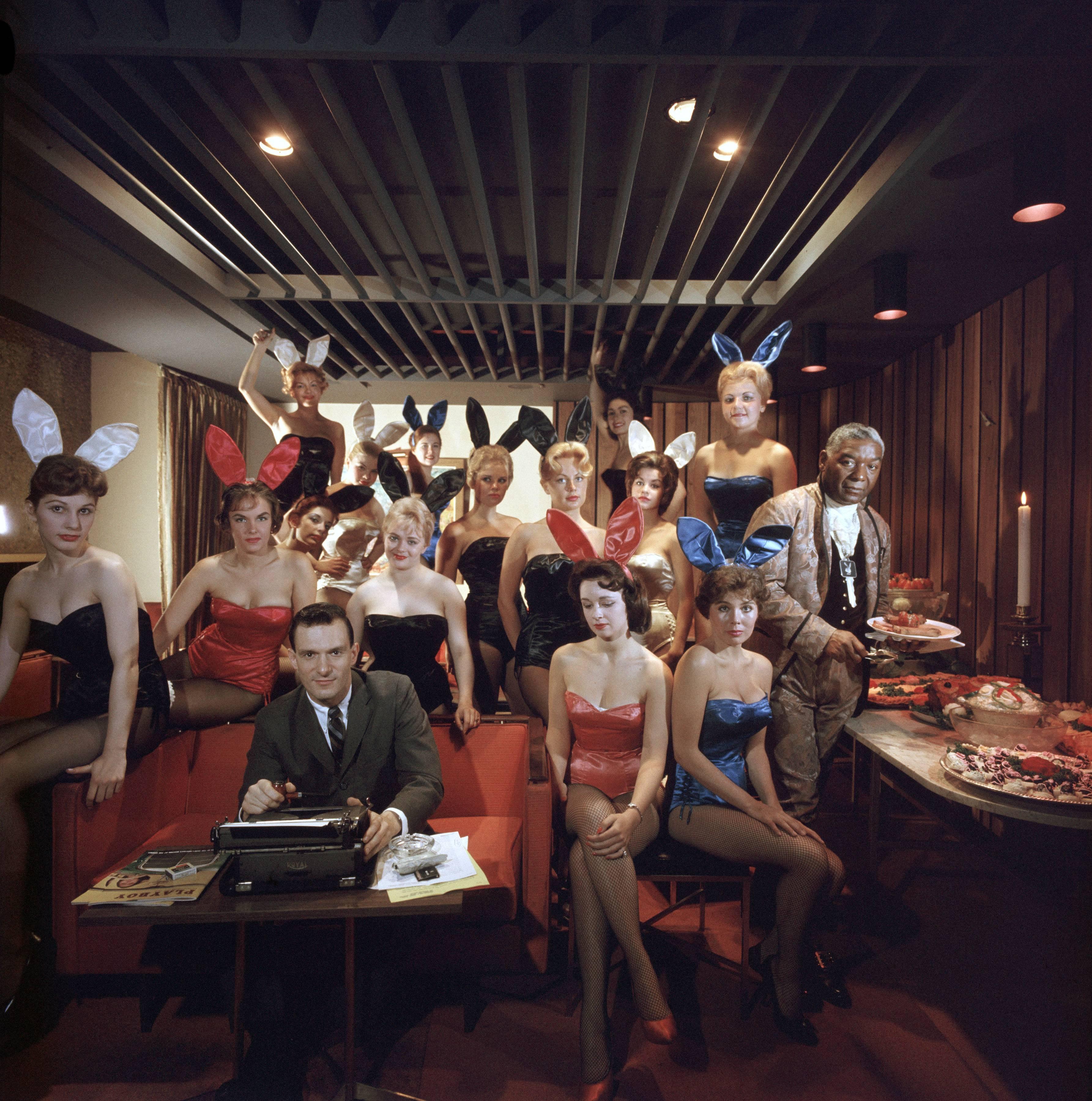 Slim Aarons Color Photograph - Man's Work, 1960: Hugh Hefner and Bunnies at the Playboy Key Club, Chicago