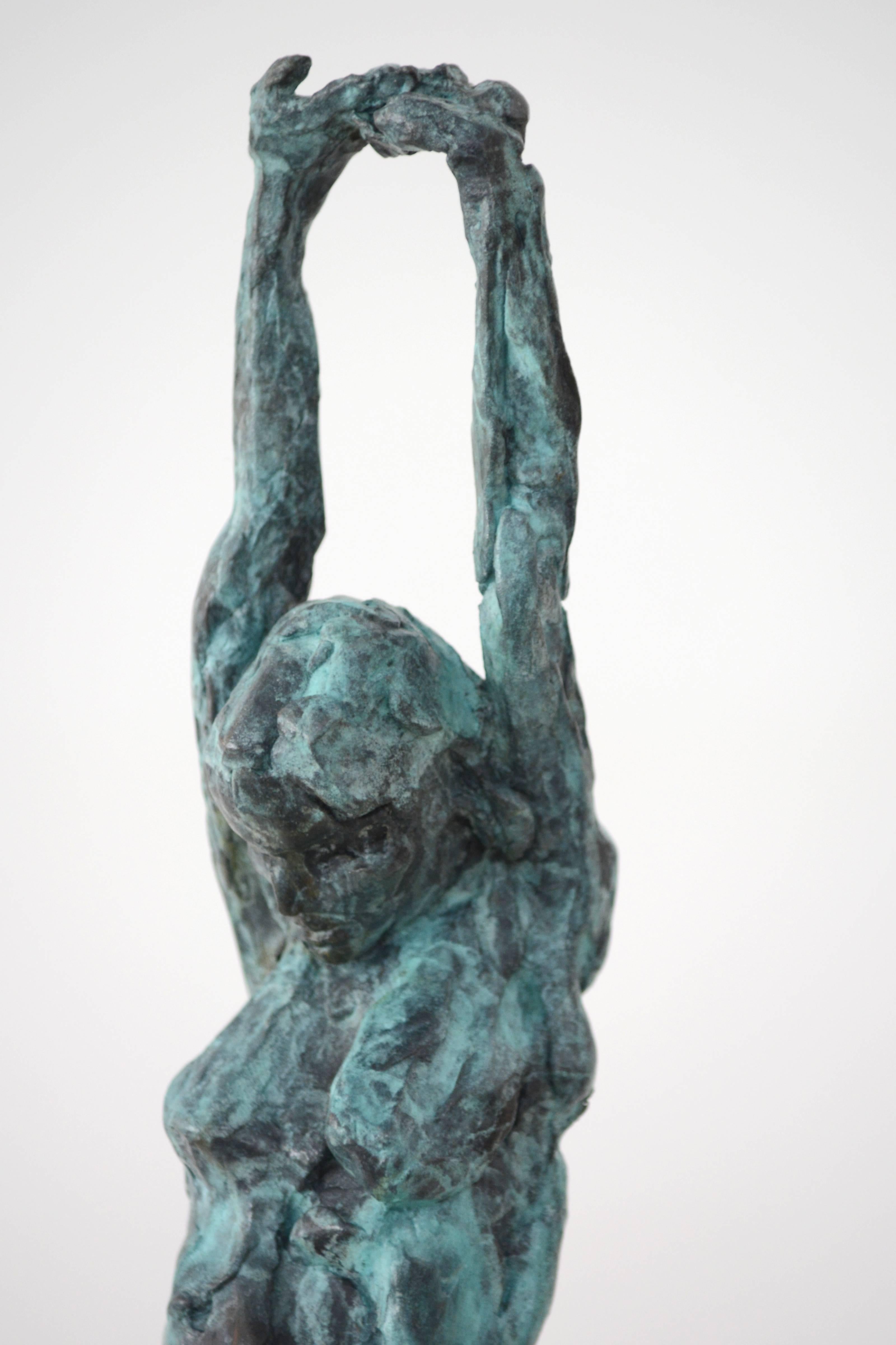 This female figure has her arms fully extended over her head as a dancer would stretch before performing. The light blue and green patina highlights this gesture and slowly blends downward into a mossy green and black patina by her feet. 

A