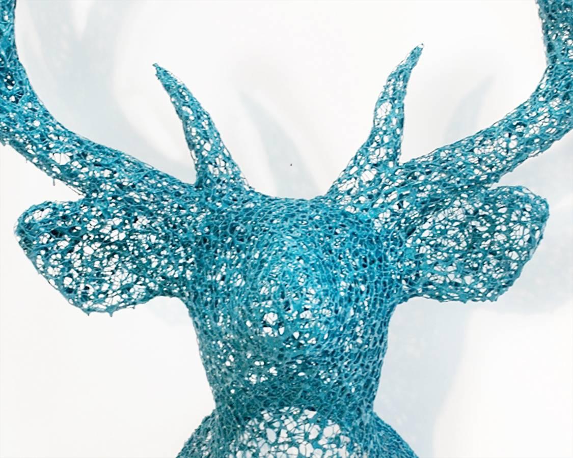 Galvanized steel mesh, wire and brilliant turquoise liquid latex are transformed into a life sized trophy head of a buck in this wall mounted sculpture. In mythology, the stag may represent the faithful, true-blue protector, messenger and intuitive.