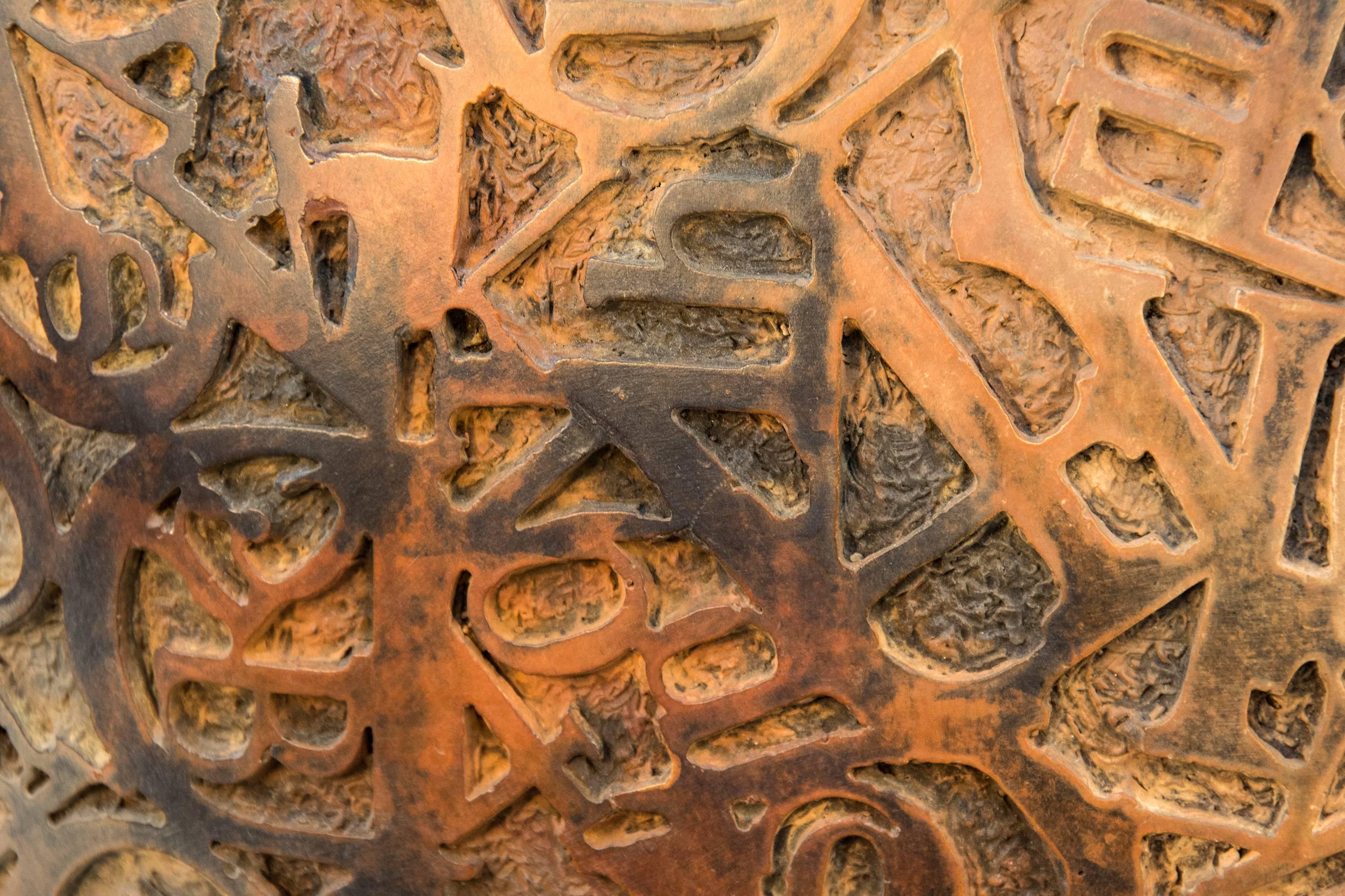 Alte Metalltypen, die zum Kopf dieser überdimensionalen Büste zusammengeschweißt wurden, sind in Bronze gegossen und stehen auf einem pyramidenförmigen Bronzesockel des Bildhauers Dale Dunning. Der Titel des Werks, Kalligraphie, bezieht sich auf