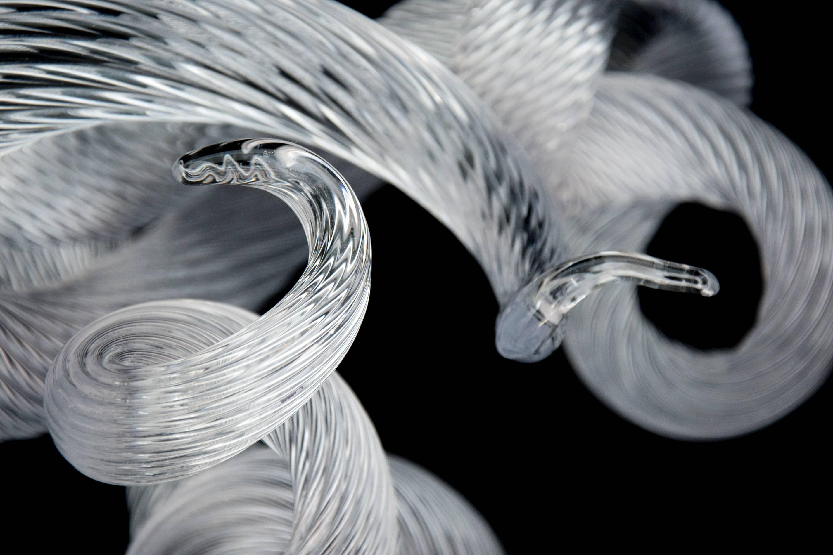 Lengths of striated clear glass are twirled and looped into playful yet elegant breaking waves by master glass artist John Paul Robinson. This dynamic work that consists of three intersecting glass sections is the first in a series of Surf