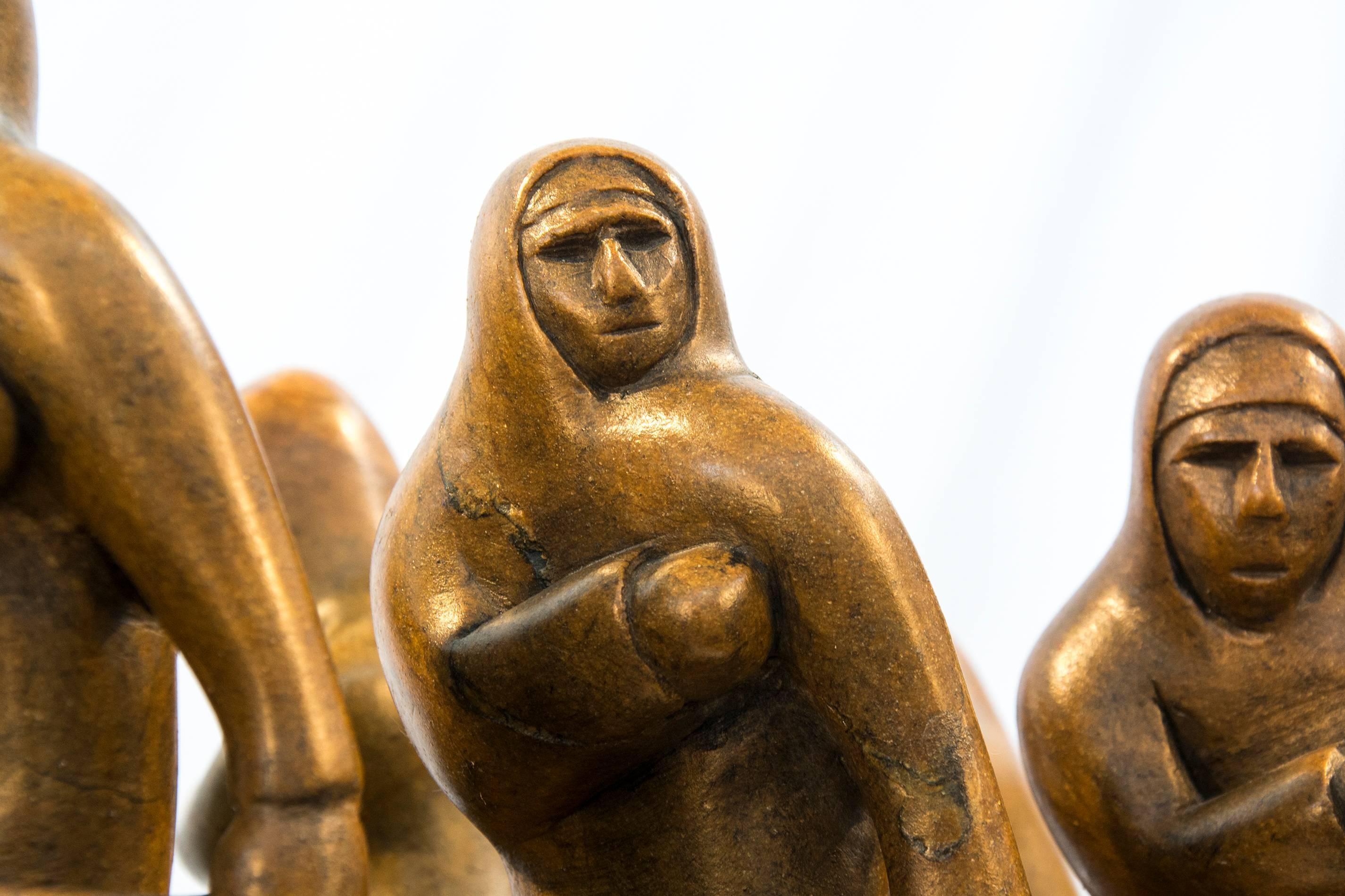 This dynamic and detailed Brazilian soapstone sculpture captures the spirit, energy and importance of a traditional Inuit hunt. Hunters dressed against the cold are on a journey in a long boat that is swept upwards by three sea creatures including
