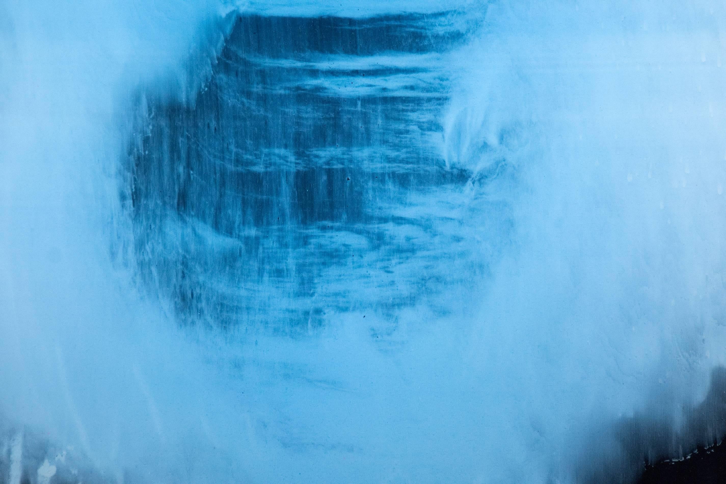 Auf diesem eleganten und gefühlvollen abstrakten Gemälde von Alice Teichert schwebt eine ringförmige blaue Wolke auf schimmernden Kohleschichten. Ein Wirrwarr von Glyphen, unterstrichen durch Streifen in Bonbonrot und -gelb, vervollständigt die