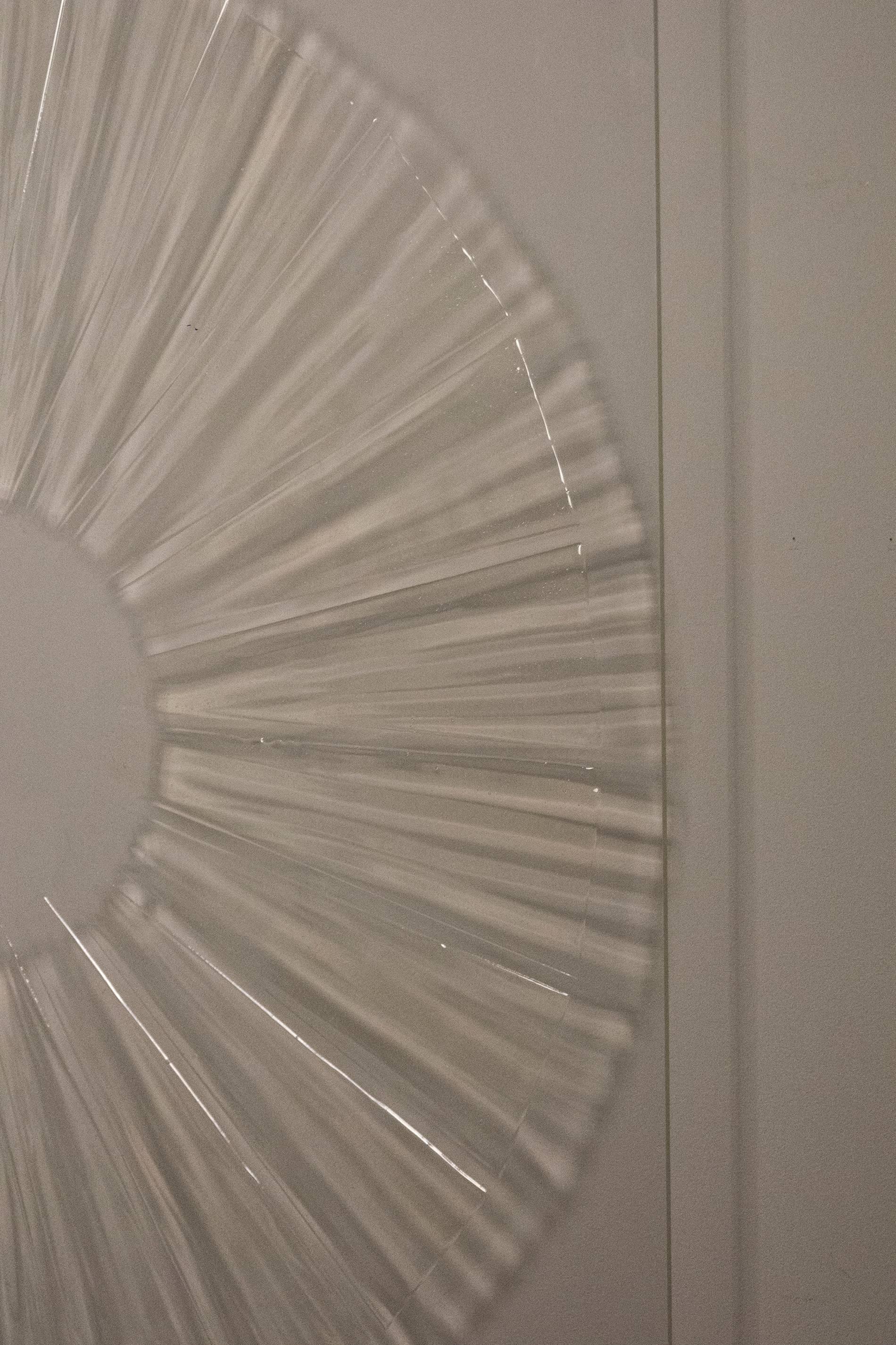 Les ombres projetées par la lumière qui traverse des motifs en gel translucide sur du plexiglas transparent créent une extension non matérielle de l'image. La peinture est fixée au mur et pend à environ quatre pouces du mur. Deux types de matériel