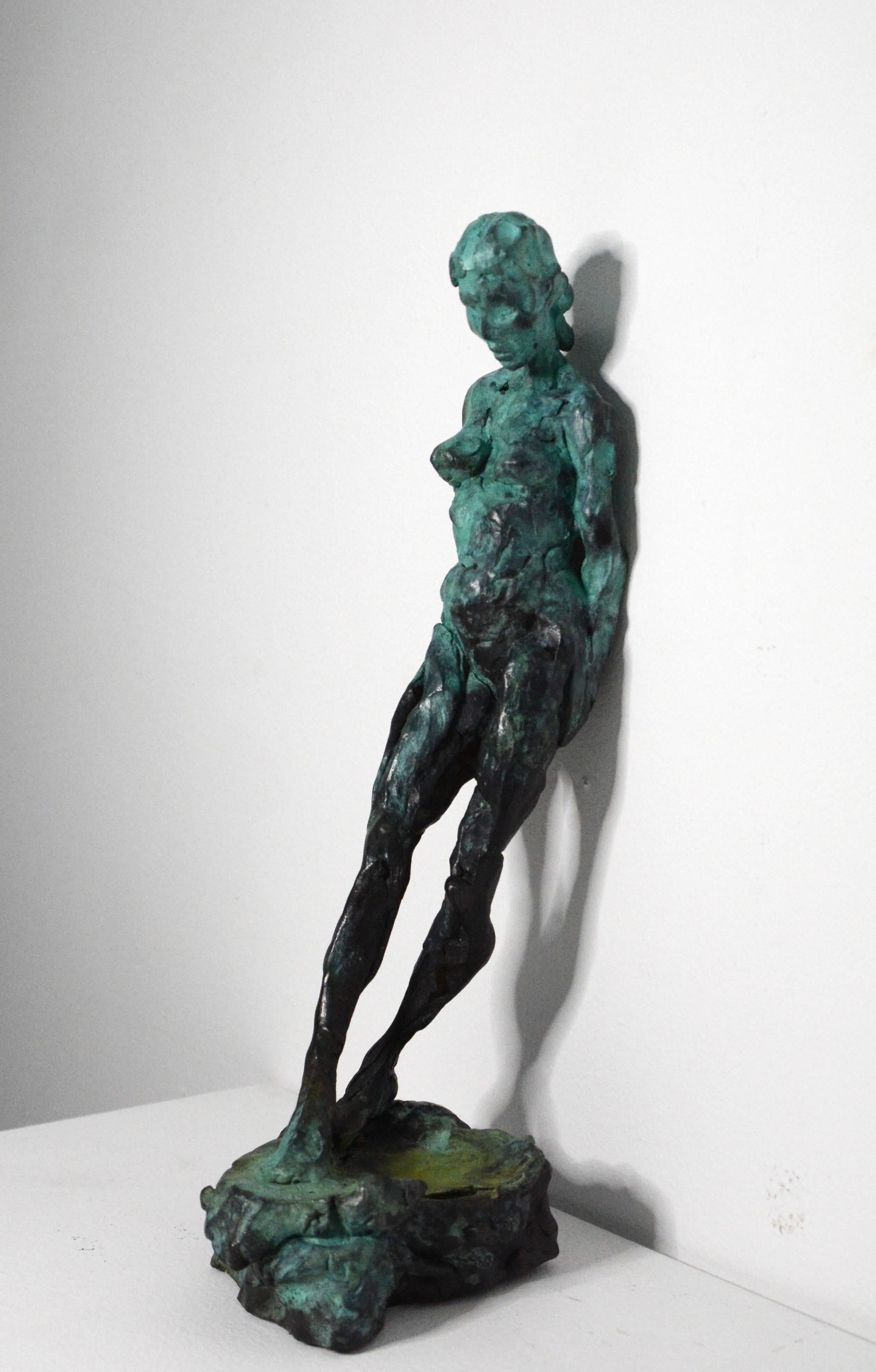 L'artiste canadien Richard Tosczak est connu pour ses magnifiques sculptures figuratives. Cette statuette en bronze représentant une femme nue appuyée contre un mur, les mains derrière le dos, a d'abord été dessinée rapidement à la plume et à