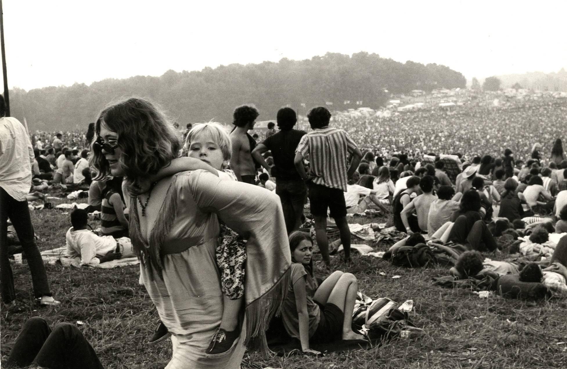 Burk Uzzle Black and White Photograph - Woodstock (woman carrying child)