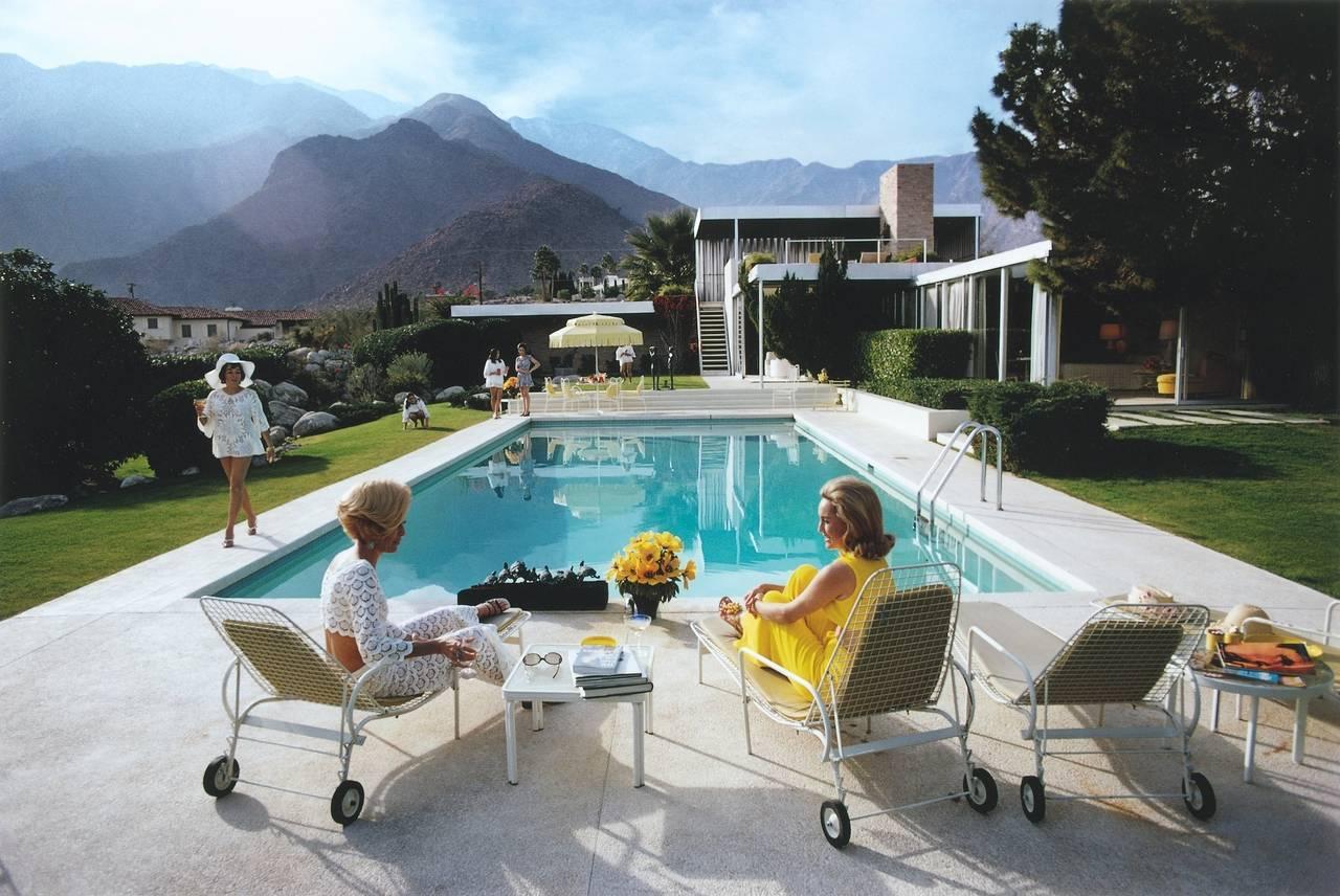 Poolside Gossip, 1970
Chromogenic Lambda print
Open edition Estate Print

A desert house in Palm Springs designed by Richard Neutra for Edgar Kaufman. Lita Baron approaches Nelda Linsk, right, wife of art dealer Joseph Linsk who is talking to a