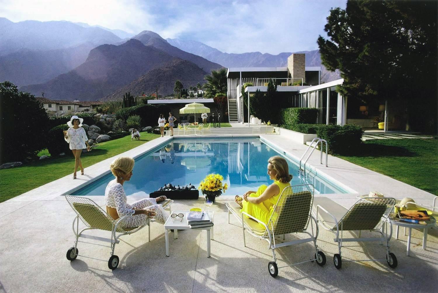 Poolside Gossip, 1970
Chromogenic lambda print
Open edition from the Slim Aarons estate

Slim Aarons (1916-2006) worked mainly for society publications photographing "attractive people doing attractive things in attractive places." Taking pictures