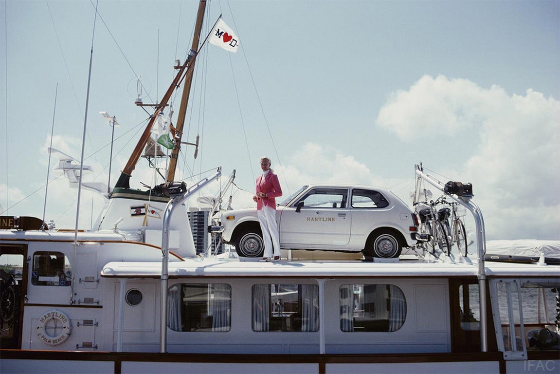 Mrs. Woolworth Donahue with car and bicycles on her motor yacht, 'Hartline', 1982.

Estate stamped and hand numbered edition of 150 with certificate of authenticity from the Slim Aarons Estate. 

Slim Aarons (1916-2006) worked mainly for society
