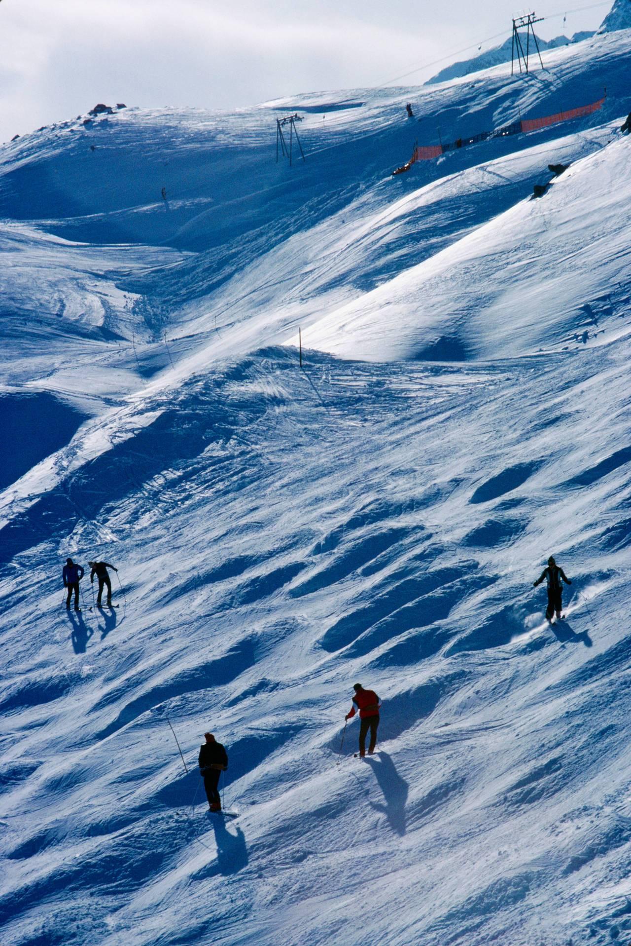 Slim Aarons Color Photograph - Skiers on a slope in St Moritz, Switzerland