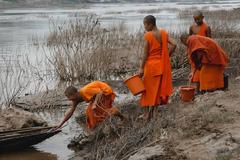 Novice Monks Collecting Mud in Luang Prabang, Laos.