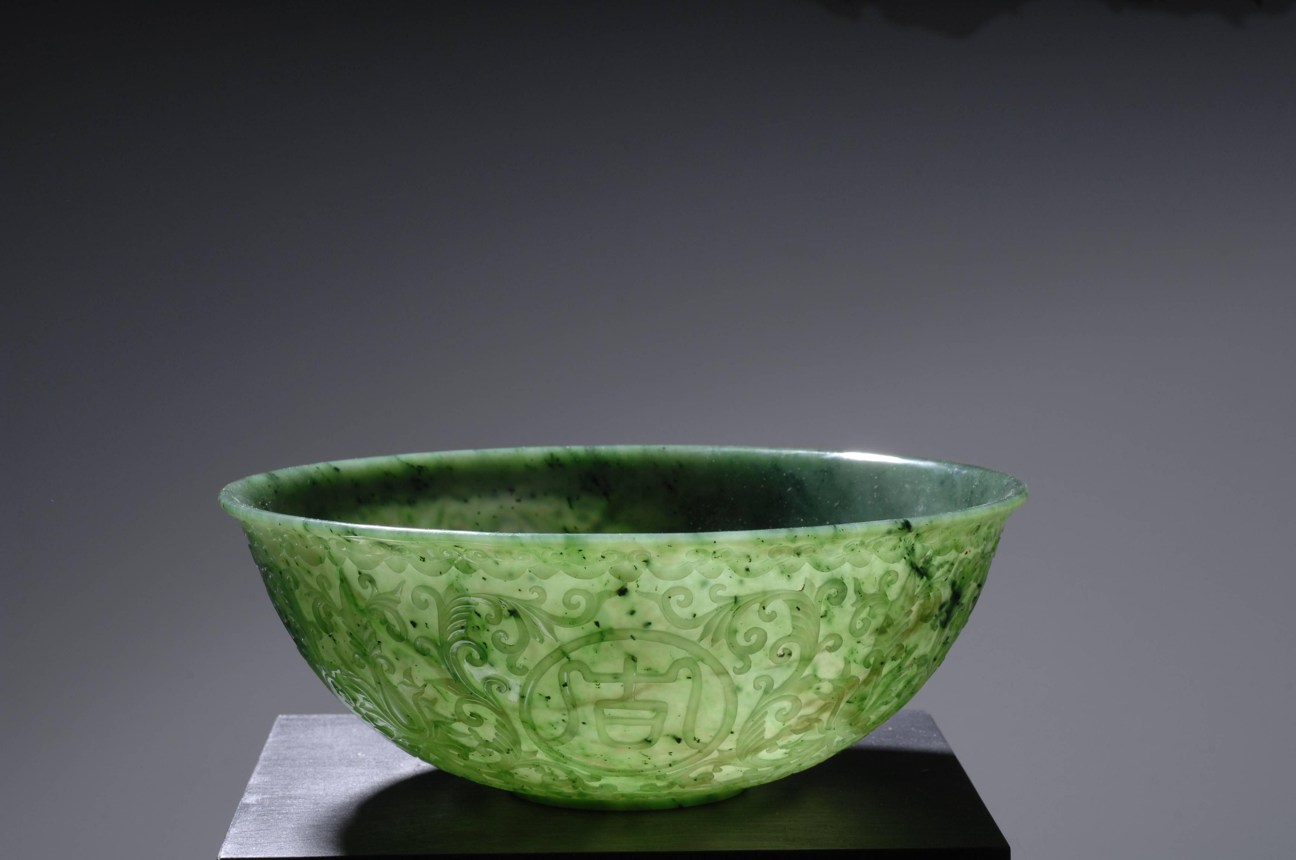 Mughal Style Green Jade Bowl, probably 19th century Chinese, the exterior is carved in low relief with scrolling vinery intersected by circular cartouches with characters; translation: Luck as your wishes, wishes as your luck