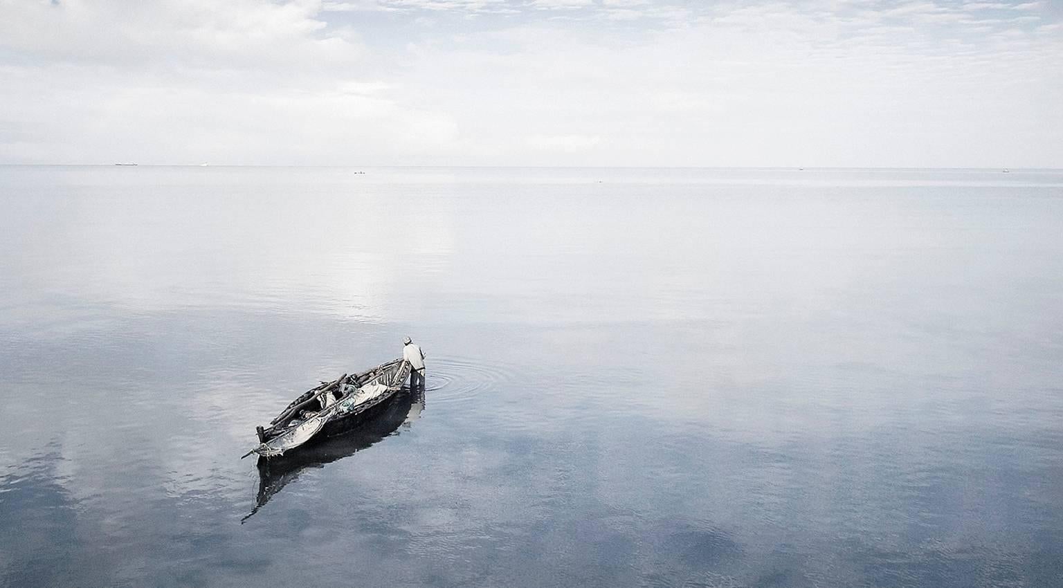 Man and Boat, Zanzibar - Photograph by Chris Gordaneer