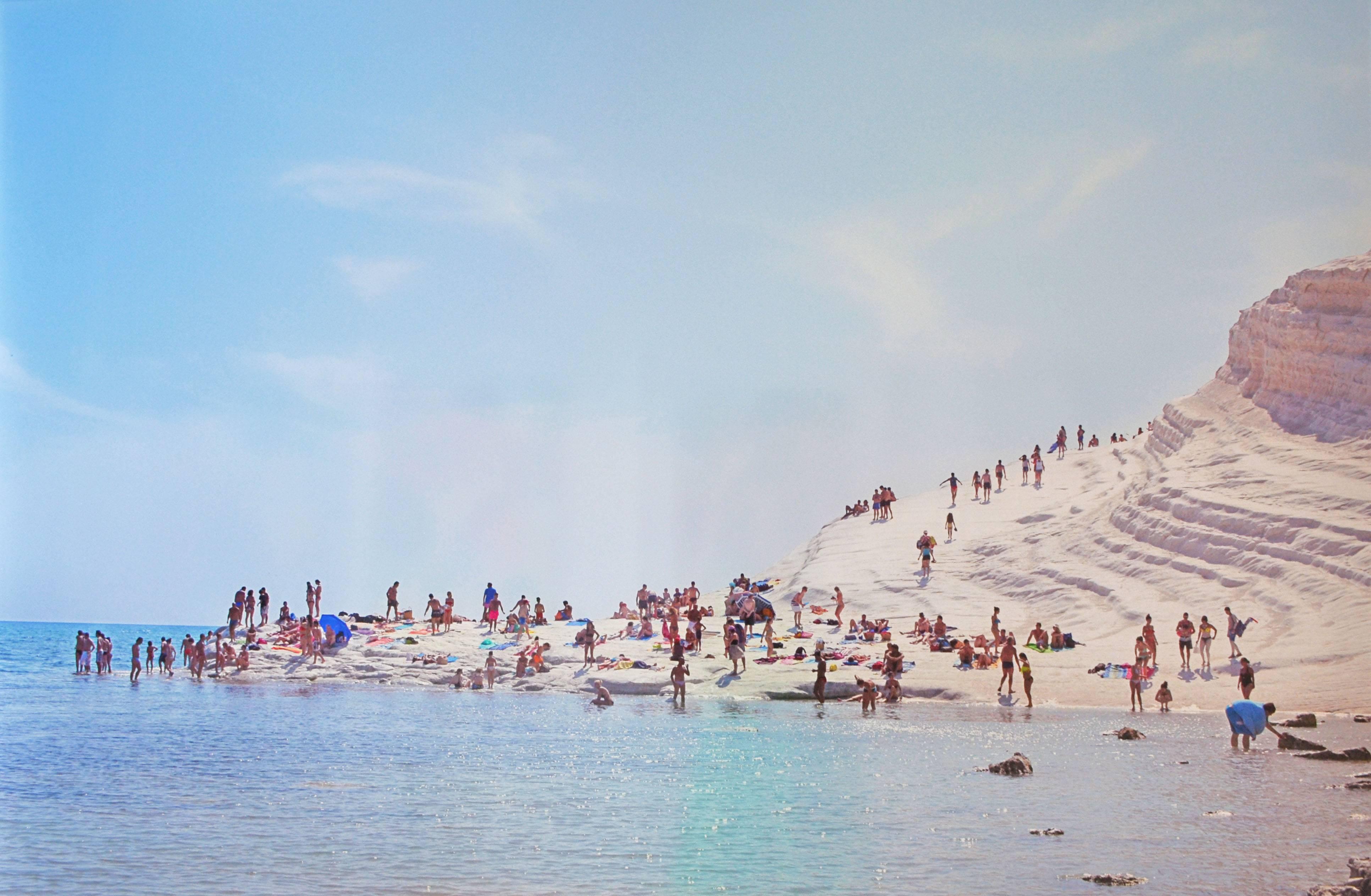 Scala dei Turchi" von DJ Leon zeigt eine Urlaubslandschaft an der italienischen Küste in Blau, Hellbraun und Rosa, 2015. Chromogener Druck, 47,5 x 68 Zoll, Auflage: 10 Stück.

DJ LEON wurde nicht formell ausgebildet.  Leon ist seit langem ein