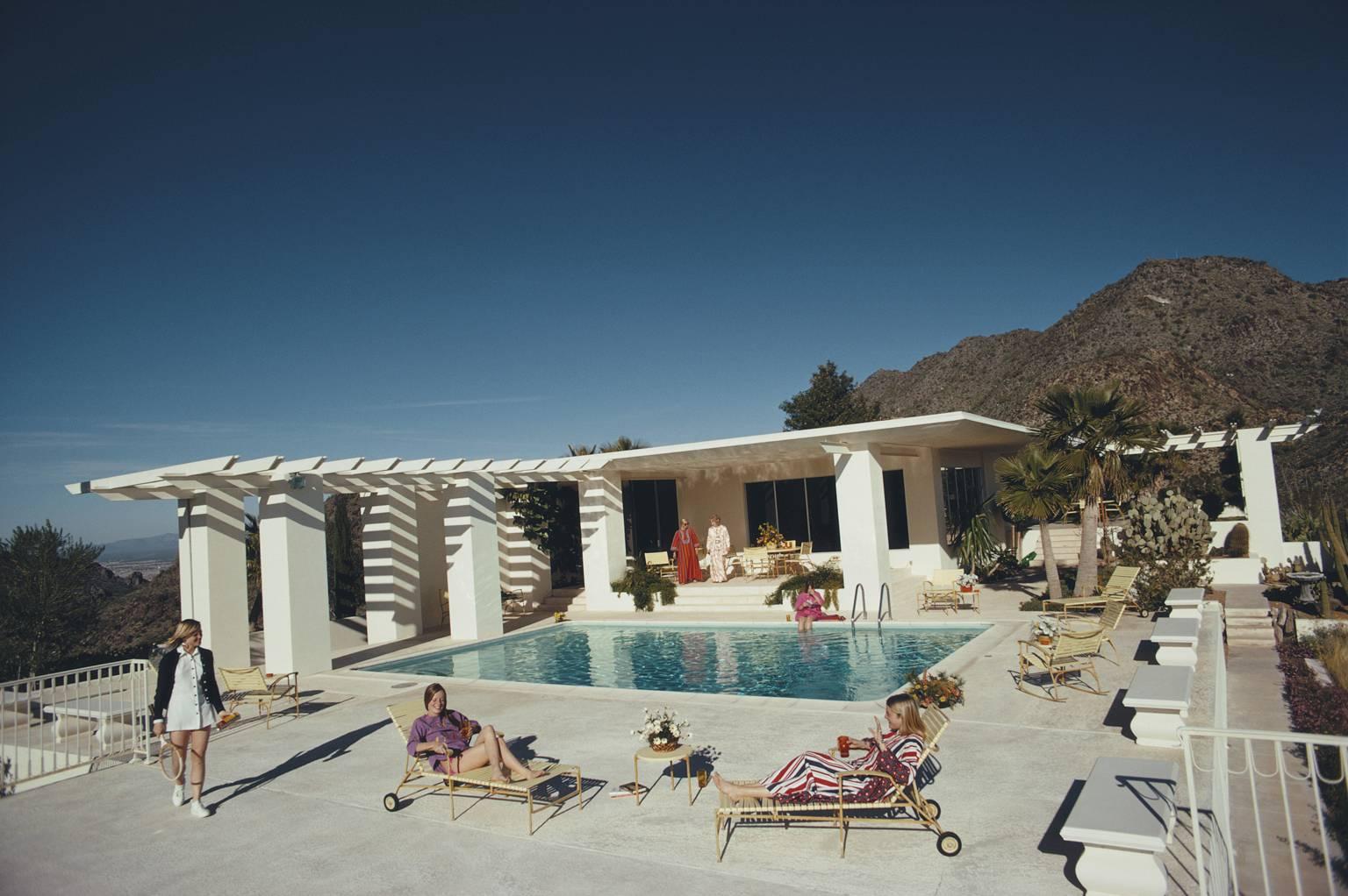 scottsdale Home" von Slim Aarons

Gäste am Pool im Haus von Wayne Beal in Scottsdale, Arizona, Januar 1973.

Man kann die Hitze kaum spüren!
Die Gäste entspannen sich im wunderschönen türkisfarbenen Wasser des Swimmingpools von Wayne Beal in