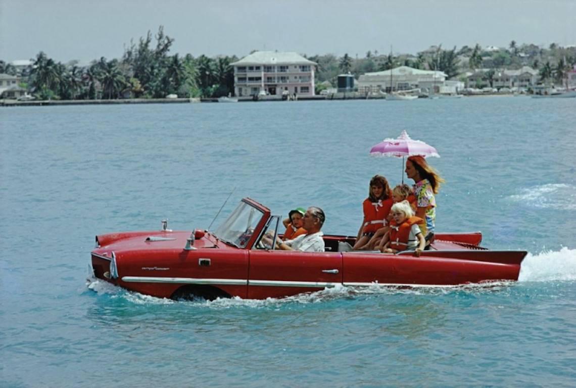 'Sea Drive' by Slim Aarons

Film producer Kevin McClory takes his wife Bobo Sigrist and their family for a drive in an 'Amphicar' across the harbour at Nassau. The children are Bianca Juarez (Bobo's daughter from another relationship) and Siobhan,