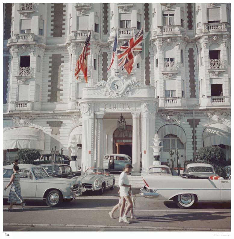 'Carlton Hotel' by Slim Aarons

The entrance to the Carlton Hotel, Cannes, France, 1958.

A couple dressed elegantly in all white tennis outfits with rackets in hand, wander past the entrance to the iconic Carlton Hotel. An array of gorgeous vintage