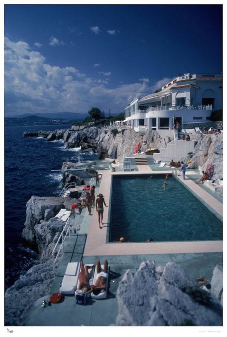 'Hotel Du Cap Eden-Roc' by Slim Aarons

*Super Oversize* print measuring a huge 72 x 48 inches

Guests relax by the pool at the Hotel du Cap Eden-Roc, Antibes, France, August 1976.

A simply gorgeous scene. Fashionable and stylish guests relax in
