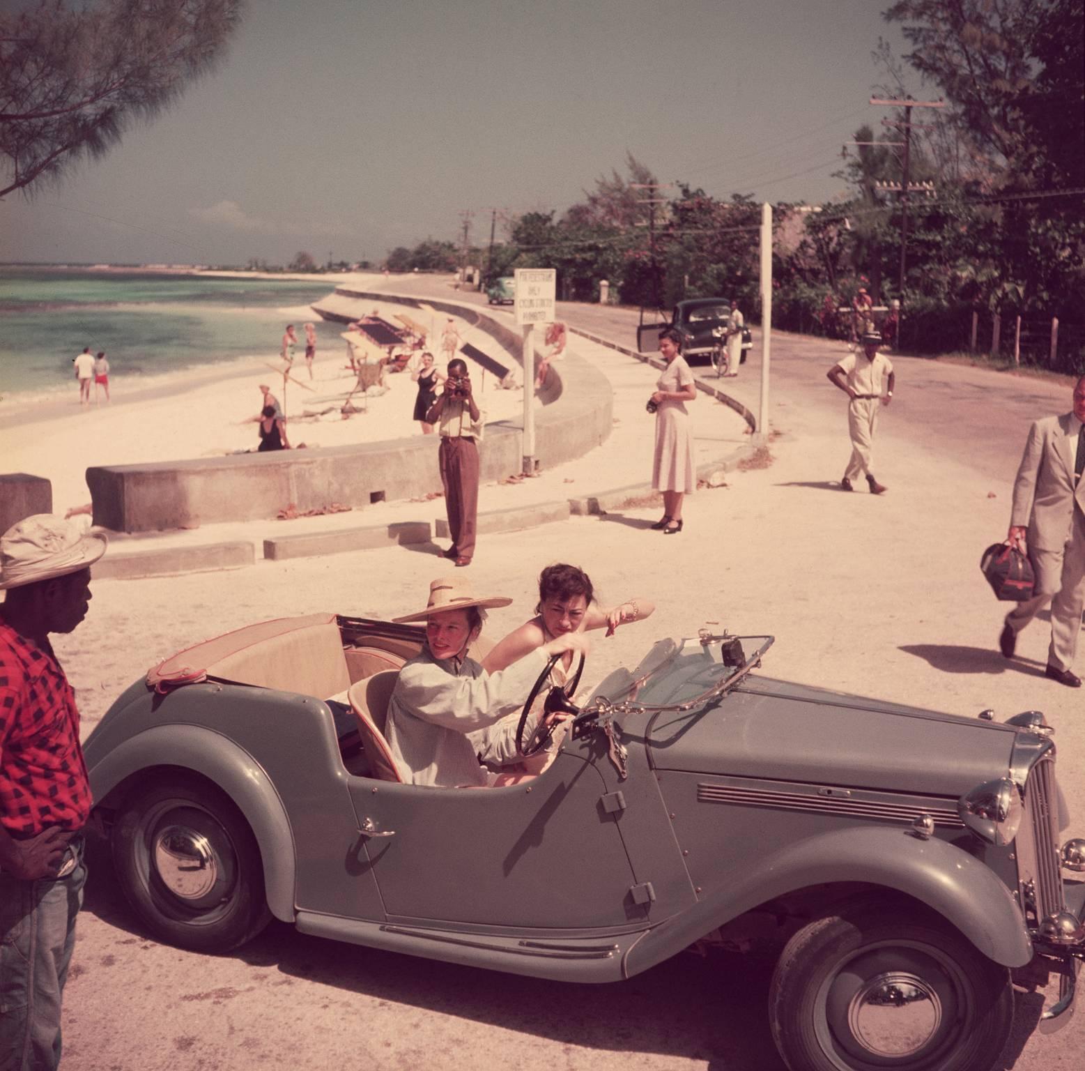 American film star Katharine Hepburn (1907 - 2003) driving along the waterfront with Irene Mayer Selznick at Montego Bay, Jamaica, 1953.

This gorgeous and vividly coloured 'Slim' photograph of beautiful film star Katharine Hepburn and producer and