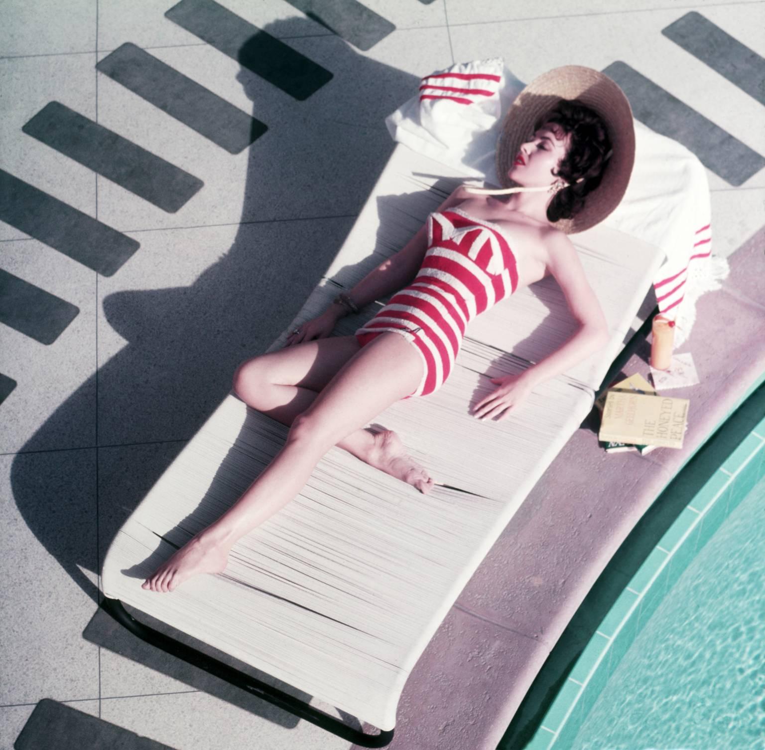 Glamorous, Austrian actress Mara Lane lounging and sunbathing by the pool in a striking red and white striped bathing costume at the Sands Hotel, Las Vegas, 1954. (Photo by Slim Aarons)

Typically 'Slim Poolside' this photograph epitomises the
