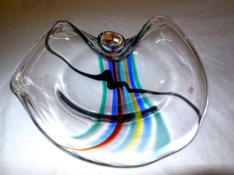 A huge centerpiece good-quality Seguso Murano (probably 1970s or 1980s, Memphis Milano era) elliptical-form clear glass sculptural bowl with striated rainbow colors of blue, orange, pink, red, yellow and green; the thick clear glass bowl with layers