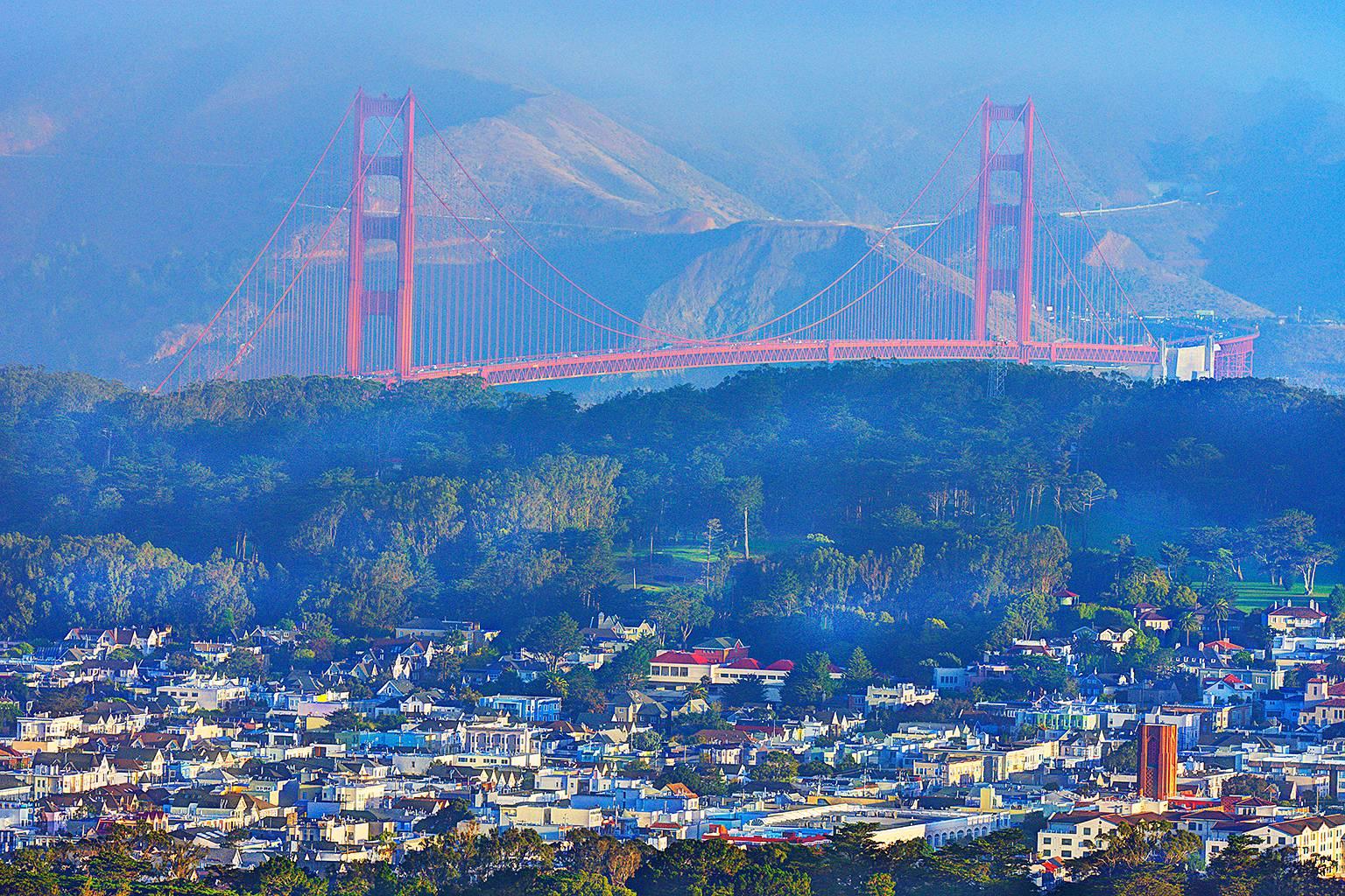 Le pont du Golden Gate au lever du soleil, la lumière brumeuse en bleu