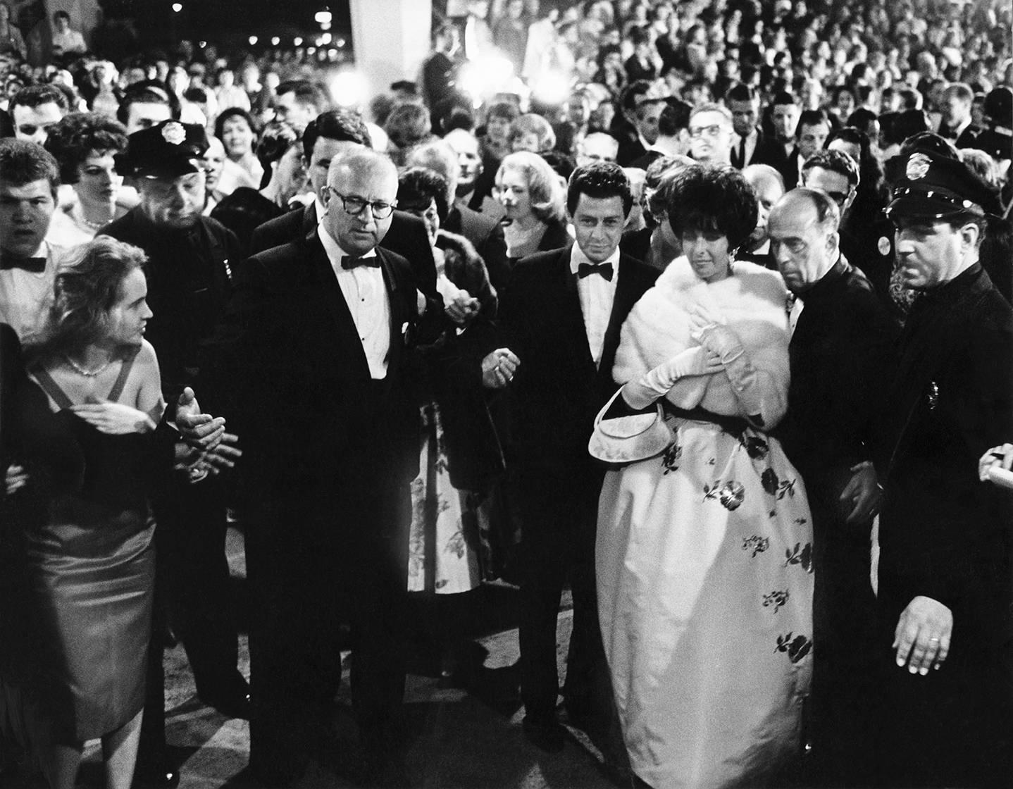 Liz Taylor bei der Oscar-Verleihung, 1961, PARIS MATCH

Dieses Foto wurde im Santa Monica Civic Auditorium an dem Abend aufgenommen, an dem Elizabeth Taylor ihren ersten Oscar für ihre Rolle in "Butterfield 8" erhielt. Bald darauf verließ sie ihren