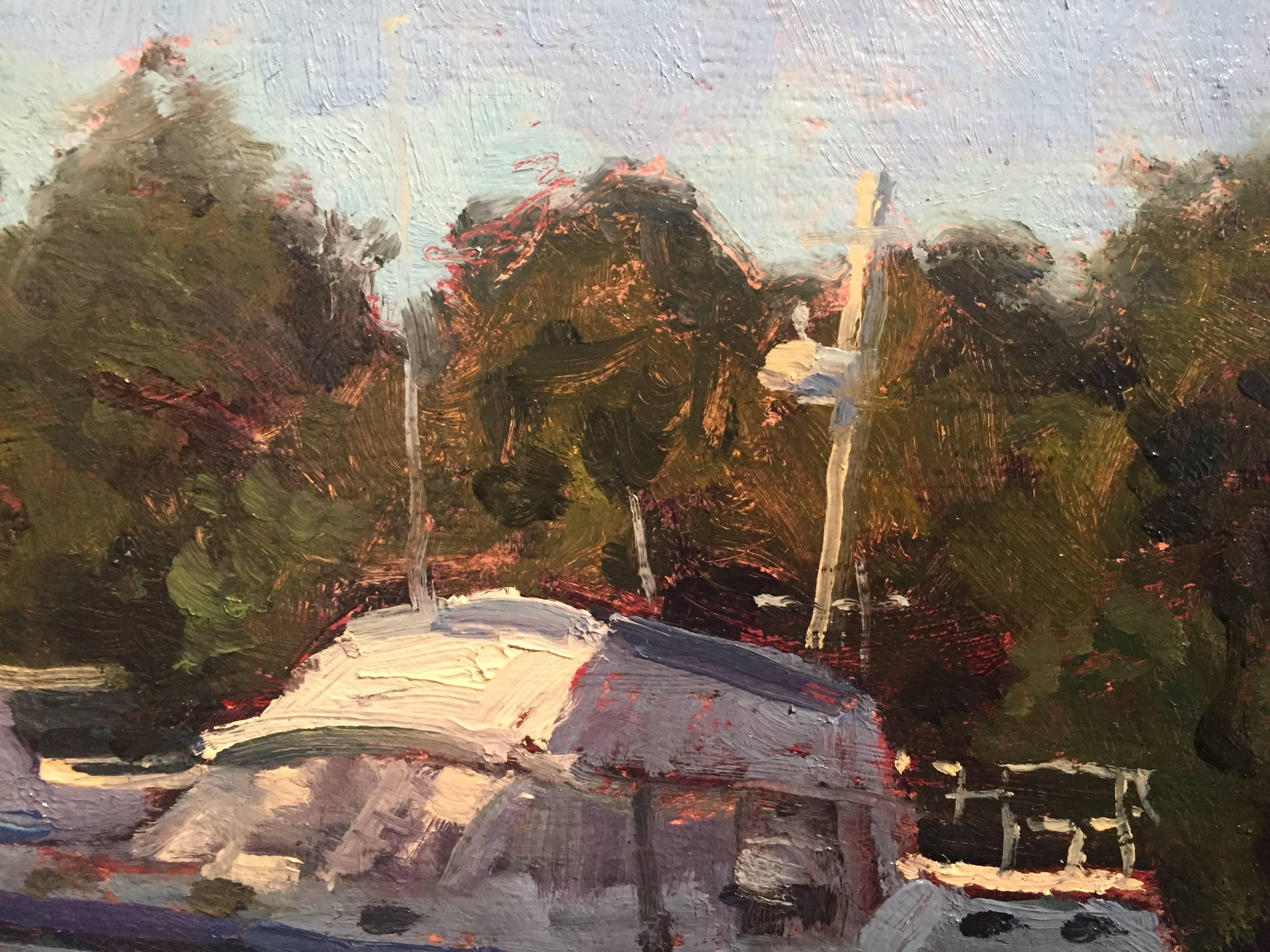 Painted en plein air in Florida, a mid-size fishing boat rests in a tree-lined harbor. Rocks and dirt are portrayed in hues of purple, brown and yellow in the foreground. A white heron stands perched at the edge of the water, which is reflecting the