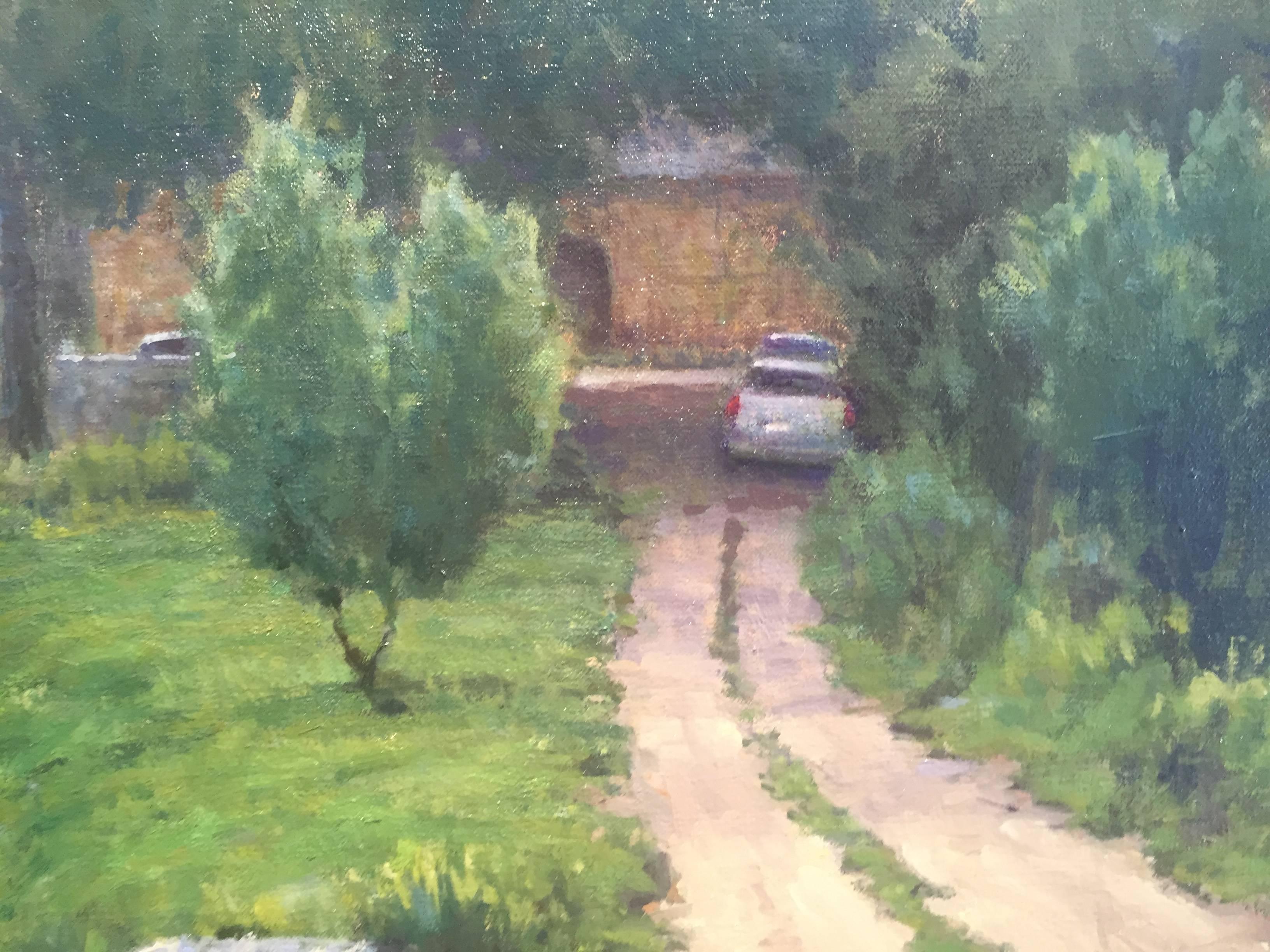 Painted en plein air, in Italy, where the earth is lush with greenery. Different tones of green create depth. A dirt road, runs vertical toward the horizon, where a car sits shaded, beneath a great big tree. Beyond the car and the tree lays a large