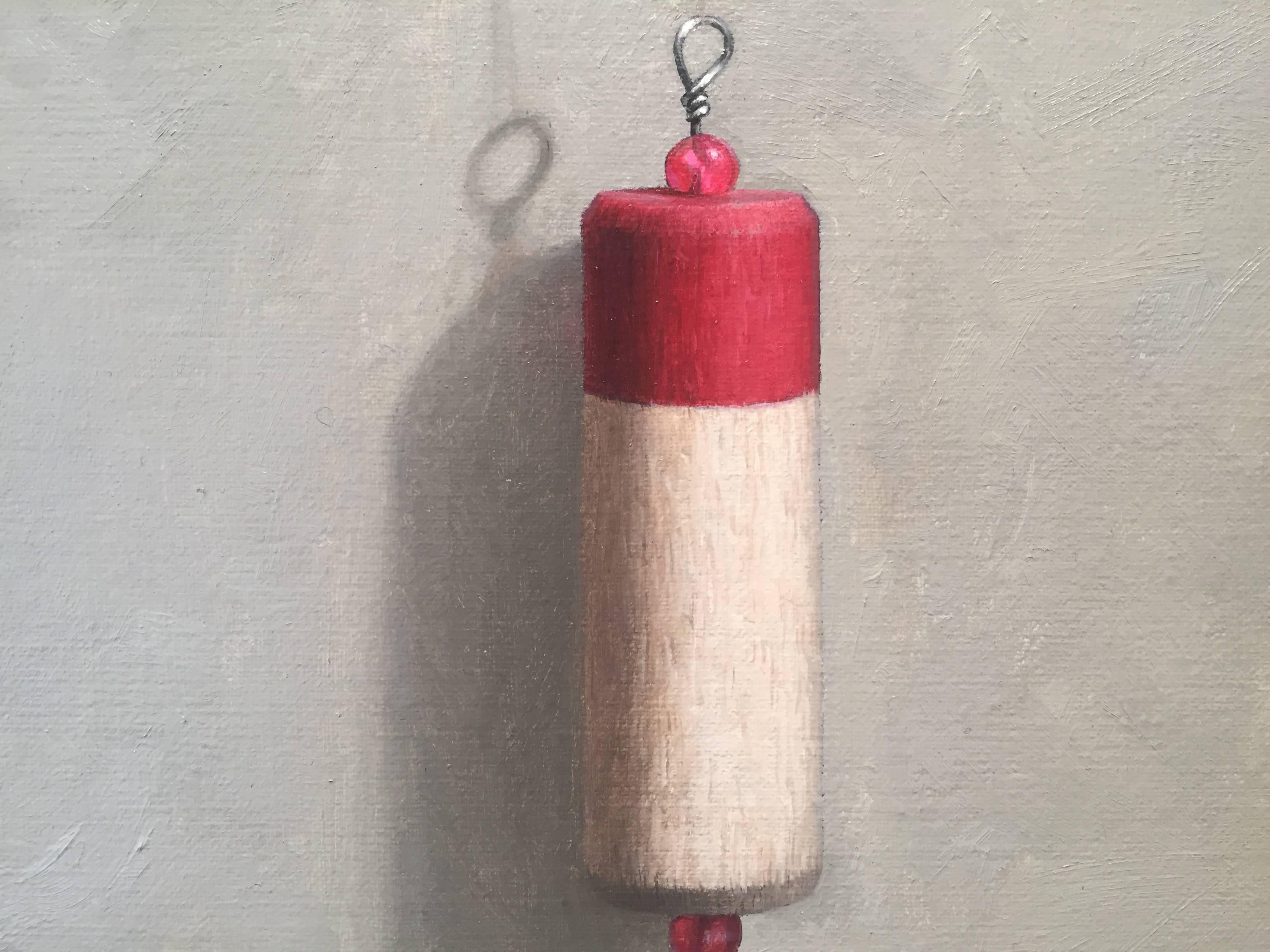 Painted from life in his Connecticut studio, John Morfis paints a red and white fishing bobber in front of a grey backdrop. Hanging from a tiny nail and a near invisible fishing wire, Morfis presents his aptitude for intricacy. 

John Morfis was