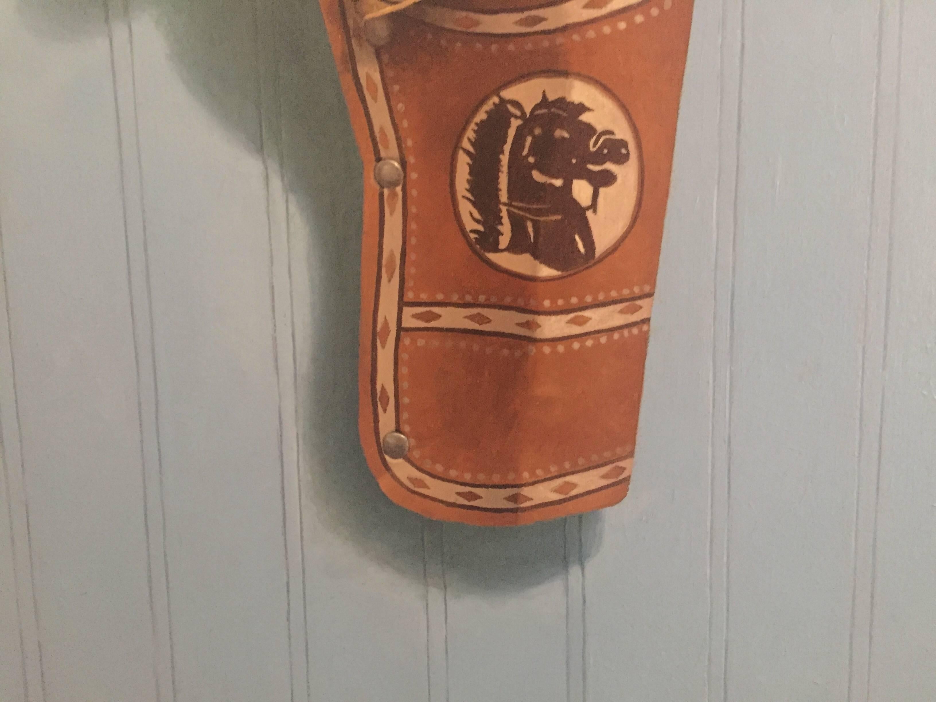 Painted from life in his studio, John Morfis paints with a proclivity for precision; Trompe l'oeil. A toy gun peeks out of it's leather holster which hangs from a nail on a pale blue wall. 

BIOGRAPHY

John Morfis was born in Glen Cove, Long Island