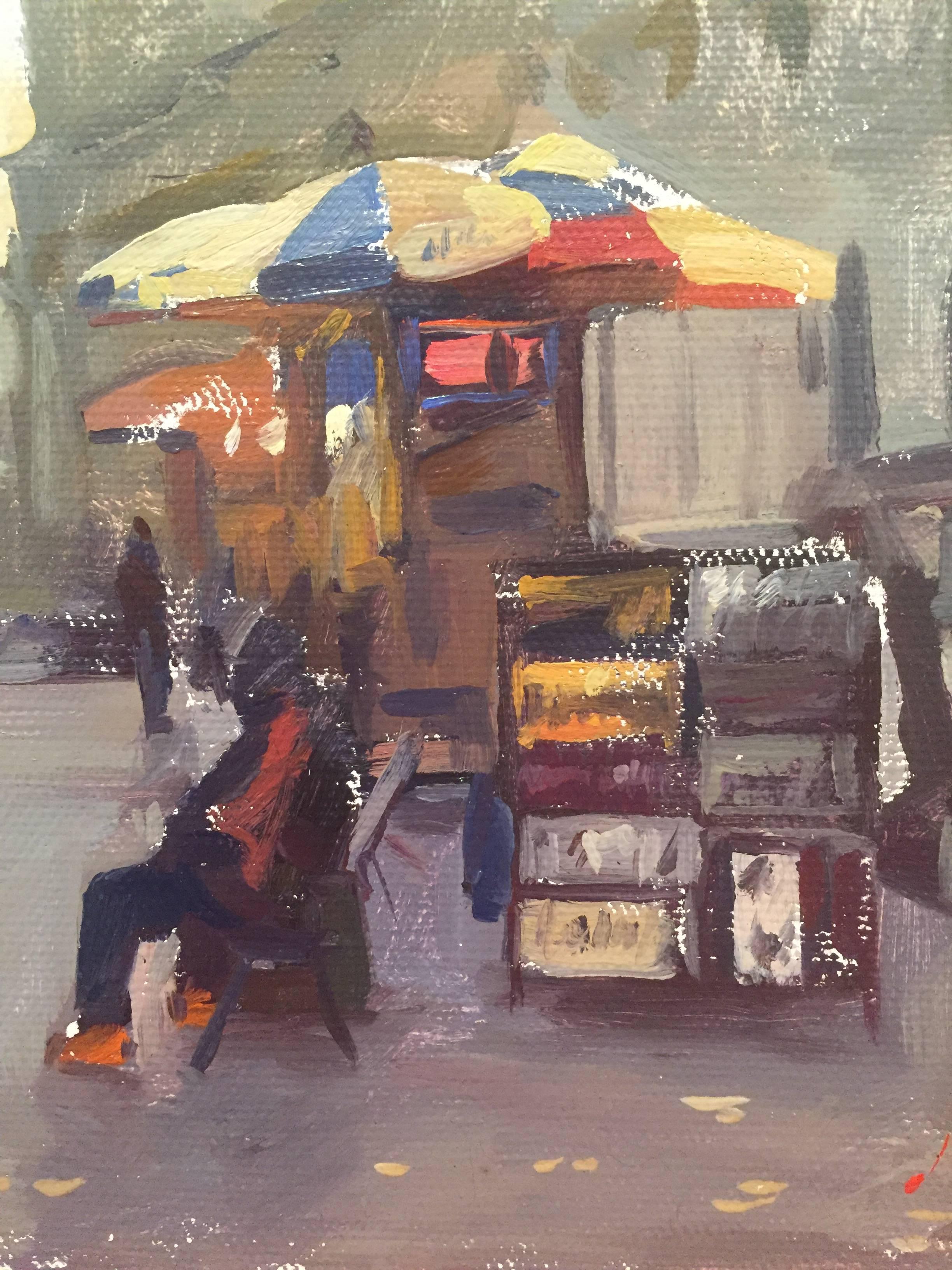 An oil painting of a New York City scene. Painted en plein air on a sidewalk in Manhattan, a figure is sitting in front of a booth of artwork underneath a colorful umbrella. Small lines of a grey-purple make up figures in the distance. A few dashes
