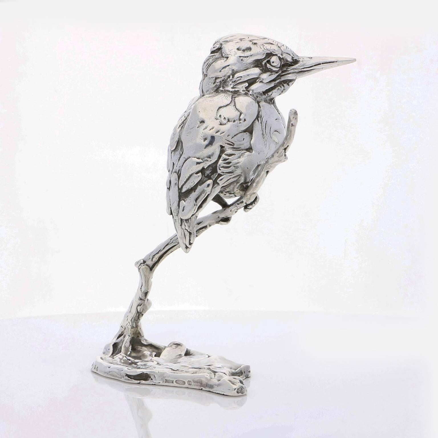 The limited edition finely modelled kingfisher perches by the river bank with his feet curled around a bare branch and his wings folded across his back.  He waits patiently, his beady eyes and long sharp beak poised and ready to dart into the water