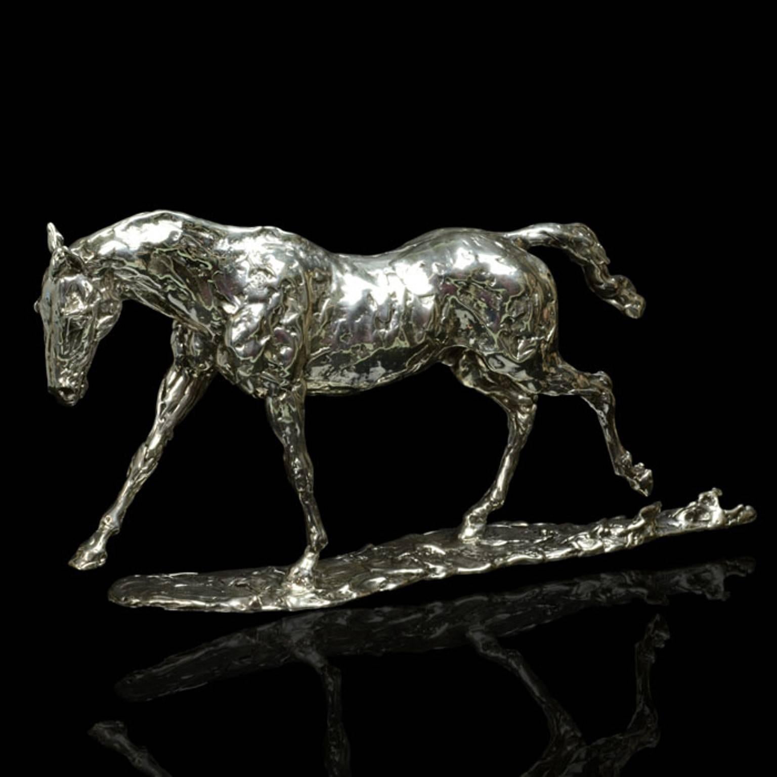 A 'Cantering Horse' sterling silver sculpture by Lucy Kinsella, the limited edition finely modelled horse is depicted mid stride as he canters across the field, opposite legs outstretched and tail flowing behind him. He has been sculpted in