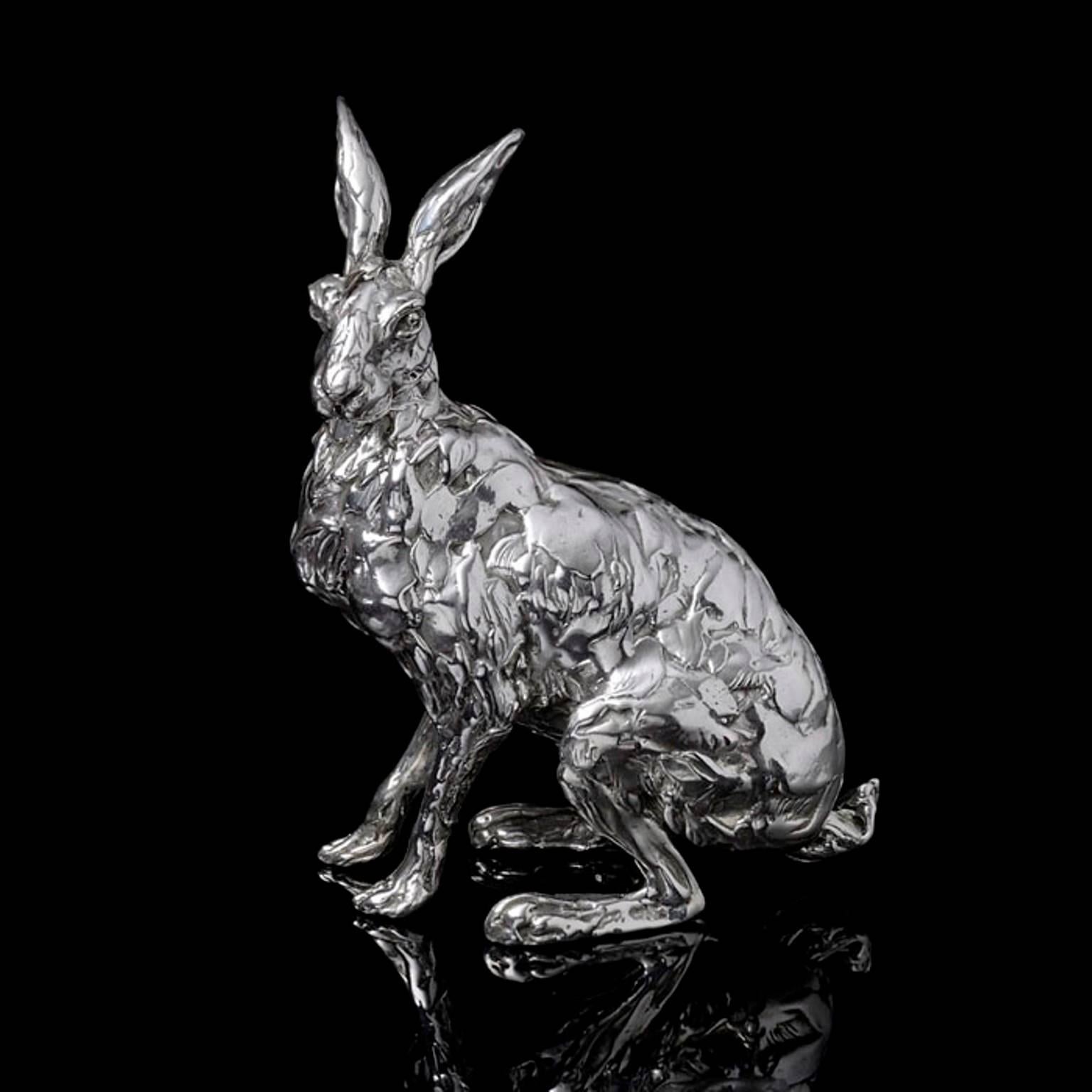 A 'Seated Hare' sterling silver sculpture by Lucy Kinsella, the limited edition finely modelled hare sits upright and alert, his front legs straight, muscles tensed, poised to run at any moment.  His long ears are held aloft and his eyes are