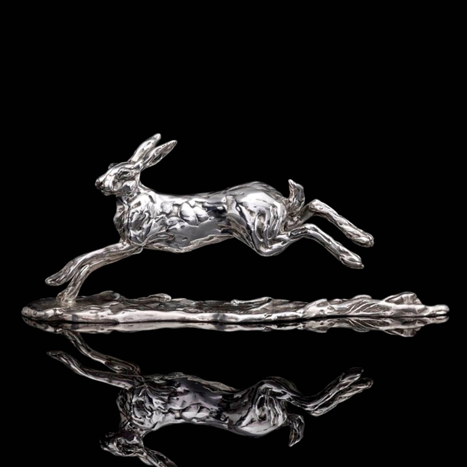 A 'Running Hare' sterling silver sculpture by Lucy Kinsella, the limited edition finely modelled hare depicted at full stretch bounding across the ground, his hind legs lengthening behind him, bob tail upright and head held high. He has been