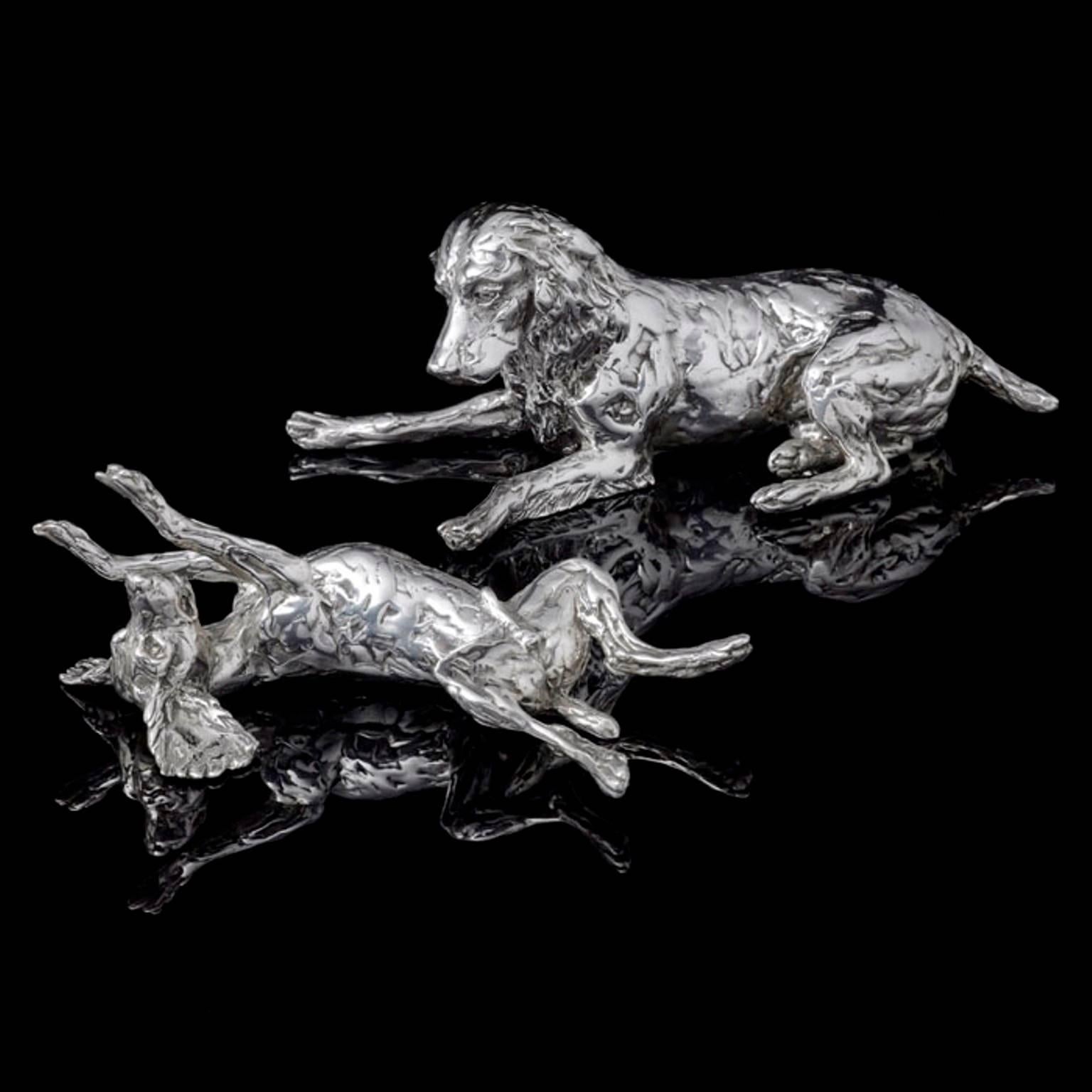 A 'Spaniel and Pup' sterling silver sculpture by Lucy Kinsella, the limited edition finely modelled spaniel lying down and watching indulgently as her puppy rolls around playfully in front of her.  The puppy lies on its back, huge ears spread out on