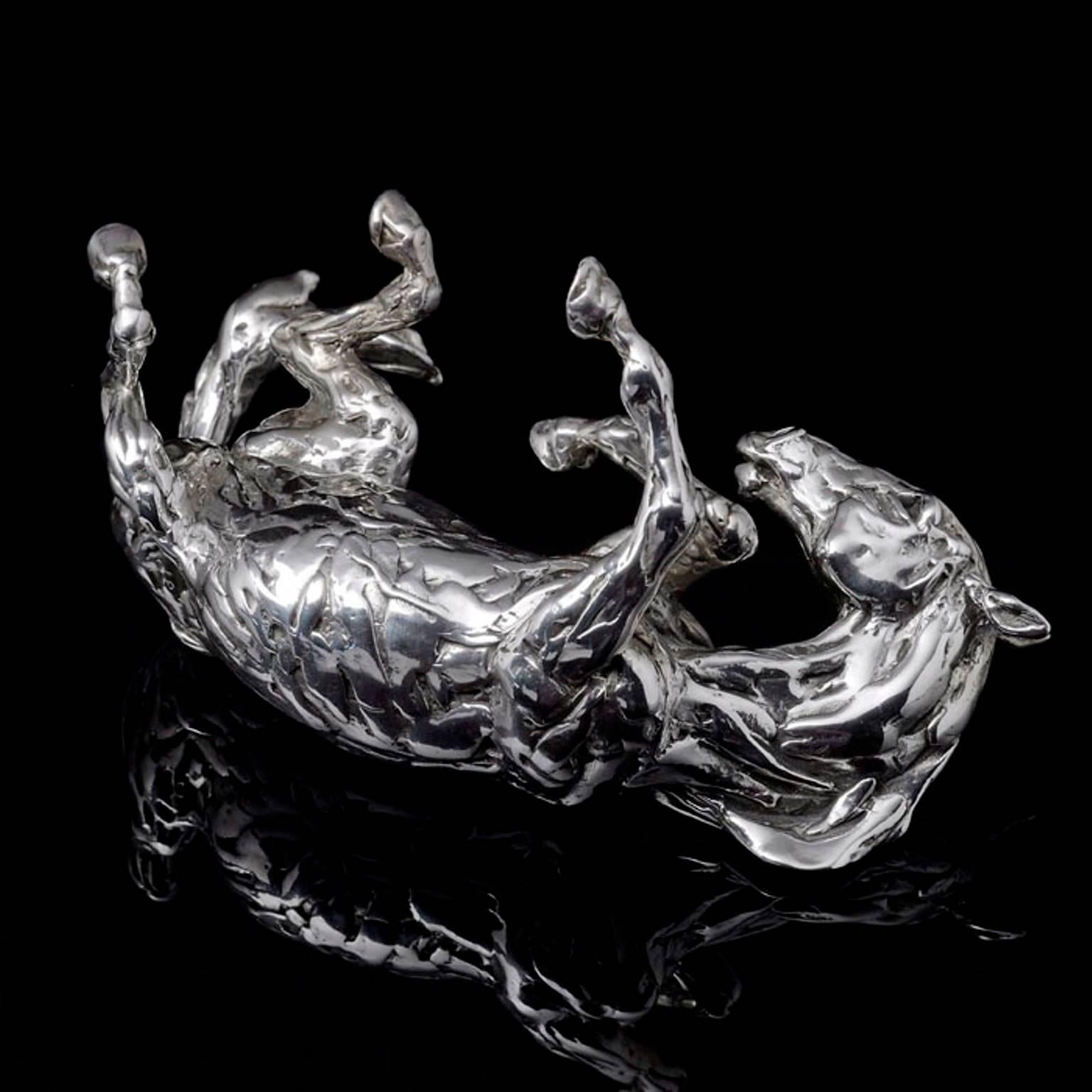 'Rolling Horse' sterling silver sculpture by Lucy Kinsella, the limited edition finely modelled horse caught mid frolic, rolling on his back with tail flicking, hooves flying and nostrils flaring.  This dynamic sculpture features Kinsella’s