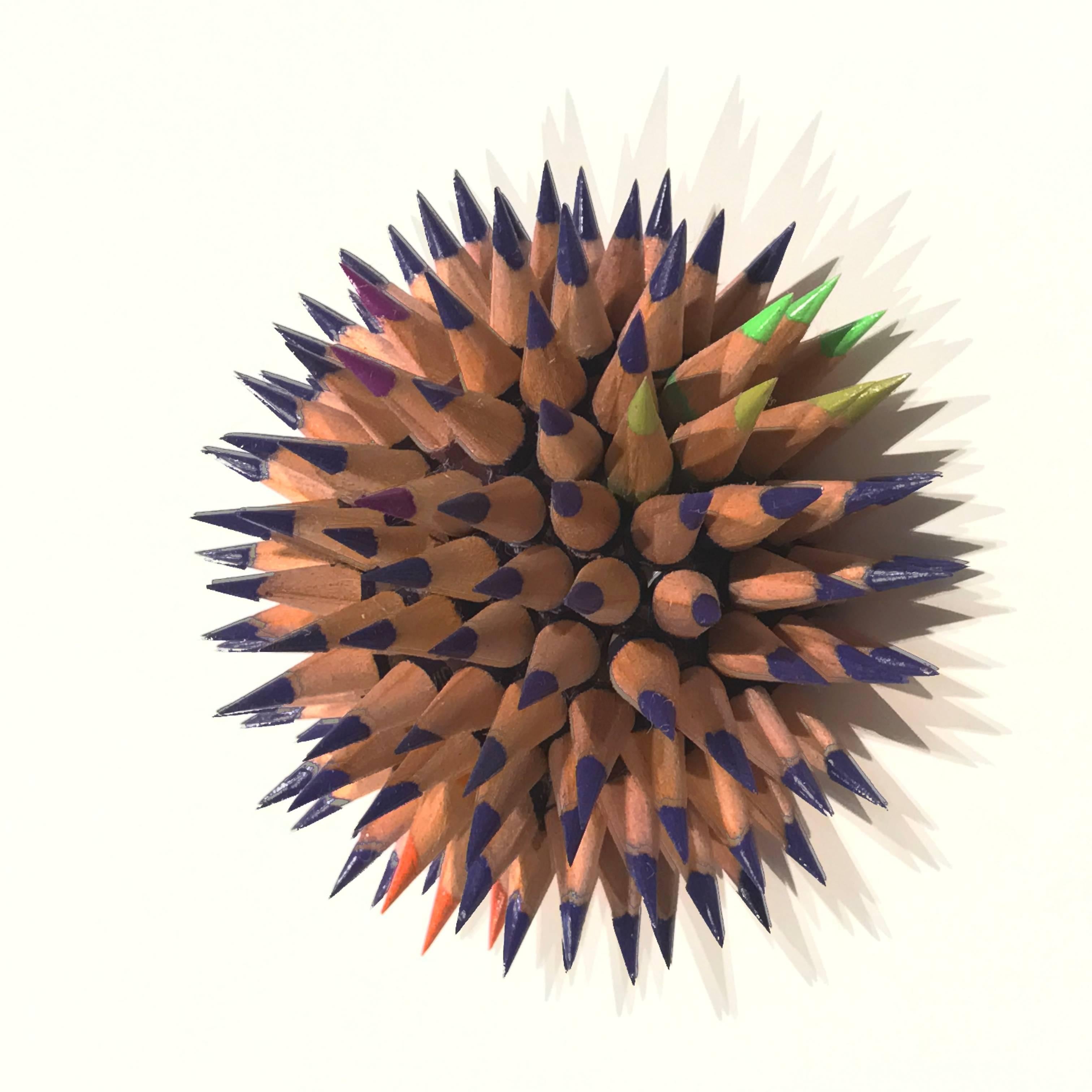 Indigo is the main color with highlights of fuschia, orange and lime green in this sculpture inspired by the sea. To make each sculpture pencils are chosen by color and cut into 1-inch sections. Holes are then drilled in each pencil, turning them