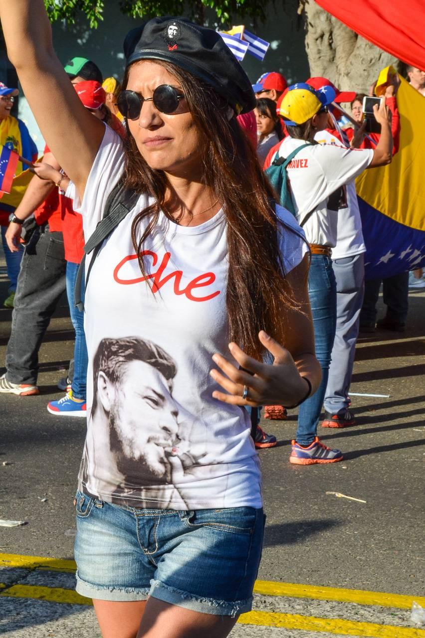 This fine art photograph shows a fashionable young woman in modern day Havana, Cuba. Her sunglasses, faded blue denim shorts, beret, and T-shirt bespeak of a contemporary character at ease in her skin. The white T-shirt exhibits the name "Che,"