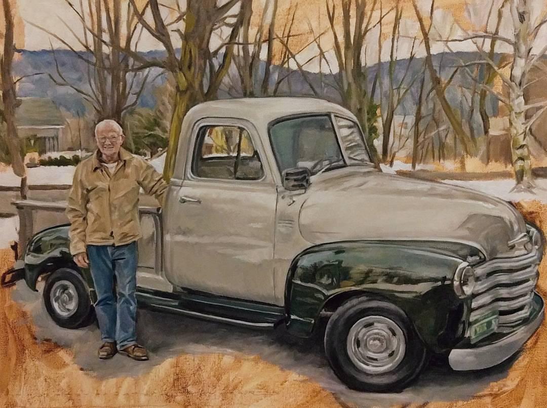 An older man stands proudly next to his vintage pickup truck in this oil painting.  The gleaming silver truck takes center stage in a wintery landscape. The olive-colored fenders are so highly polished that they serve as mirrors to the scene. This