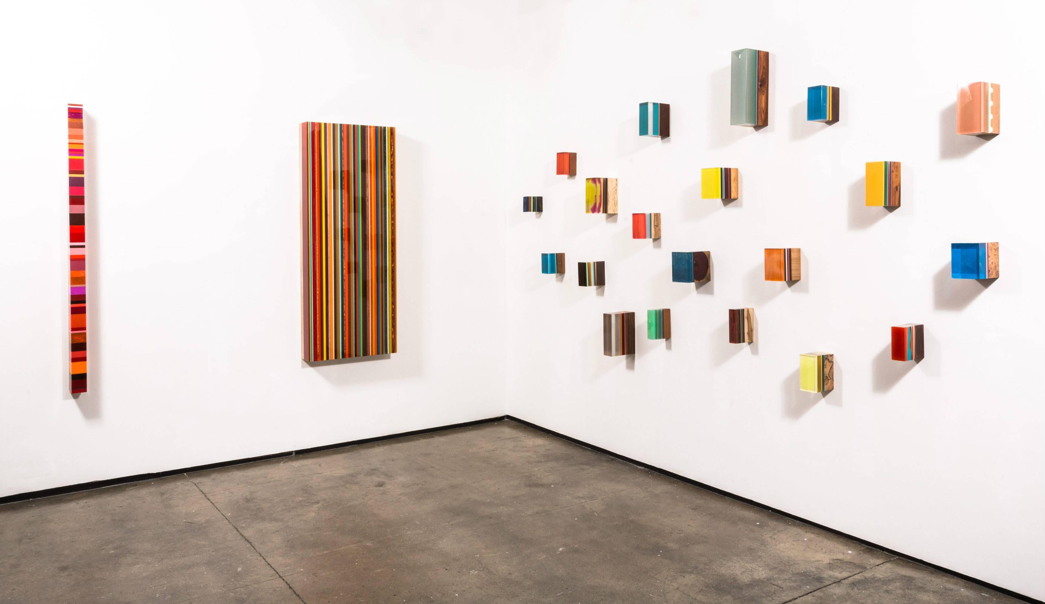 Multi-colored stripes with orange, yellow, crimson, red, green and blue
In a technique evolved over years of experimentation, Schmitz-Schmelzer pours resin in parallel or vertical layers onto a plywood-capped base of raw tropical wood. Marriage of