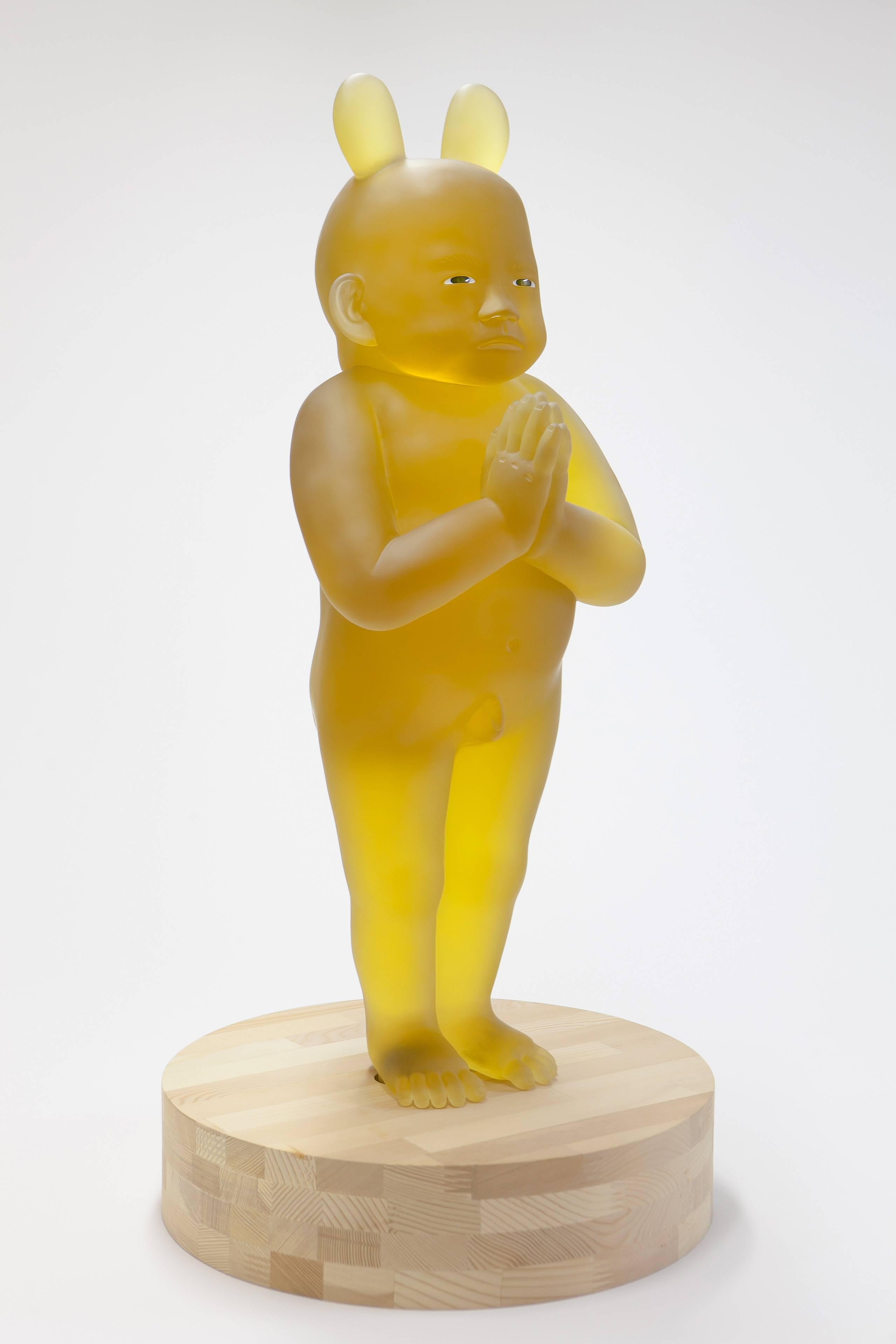 ‘Standing Baby of Kounenbutsu’ is a figurative cast glass sculpture created by Japanese artist Koichi Matsufuji in 2014. Featuring a delicate translucent golden hue, this cast glass sculpture depicts a baby in a standing position, his hands joined