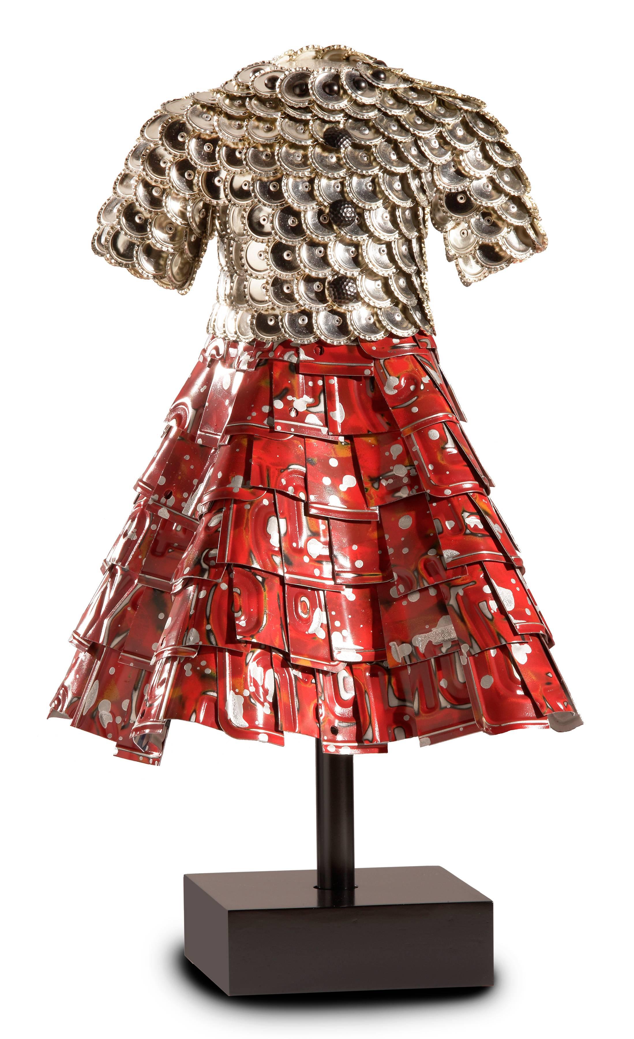 The sculpture is an artistic take of the 1960's shirtwaist dress incorporating Red/Black enamel painted embossed aluminum license plates. Dimensions are 27" T x 15" W x 1"5 D. Colors are red, silver, orange and black.